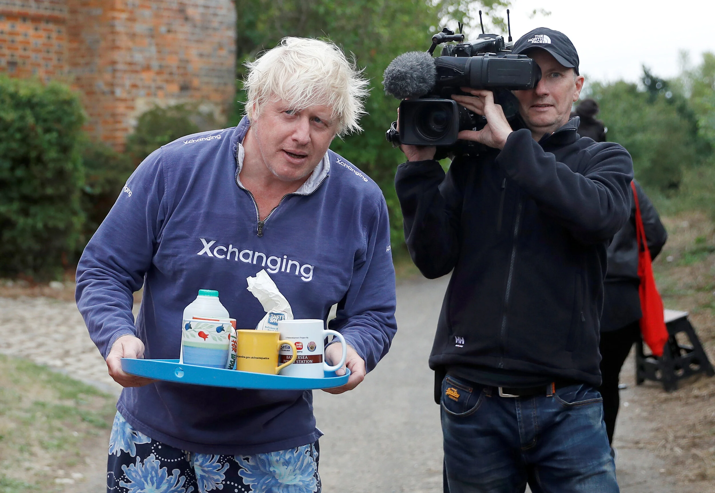  Britain's former Foreign Secretary Boris Johnson offers cups of tea to journalists outside his home near Thame in Oxfordshire, August 12, 2018 