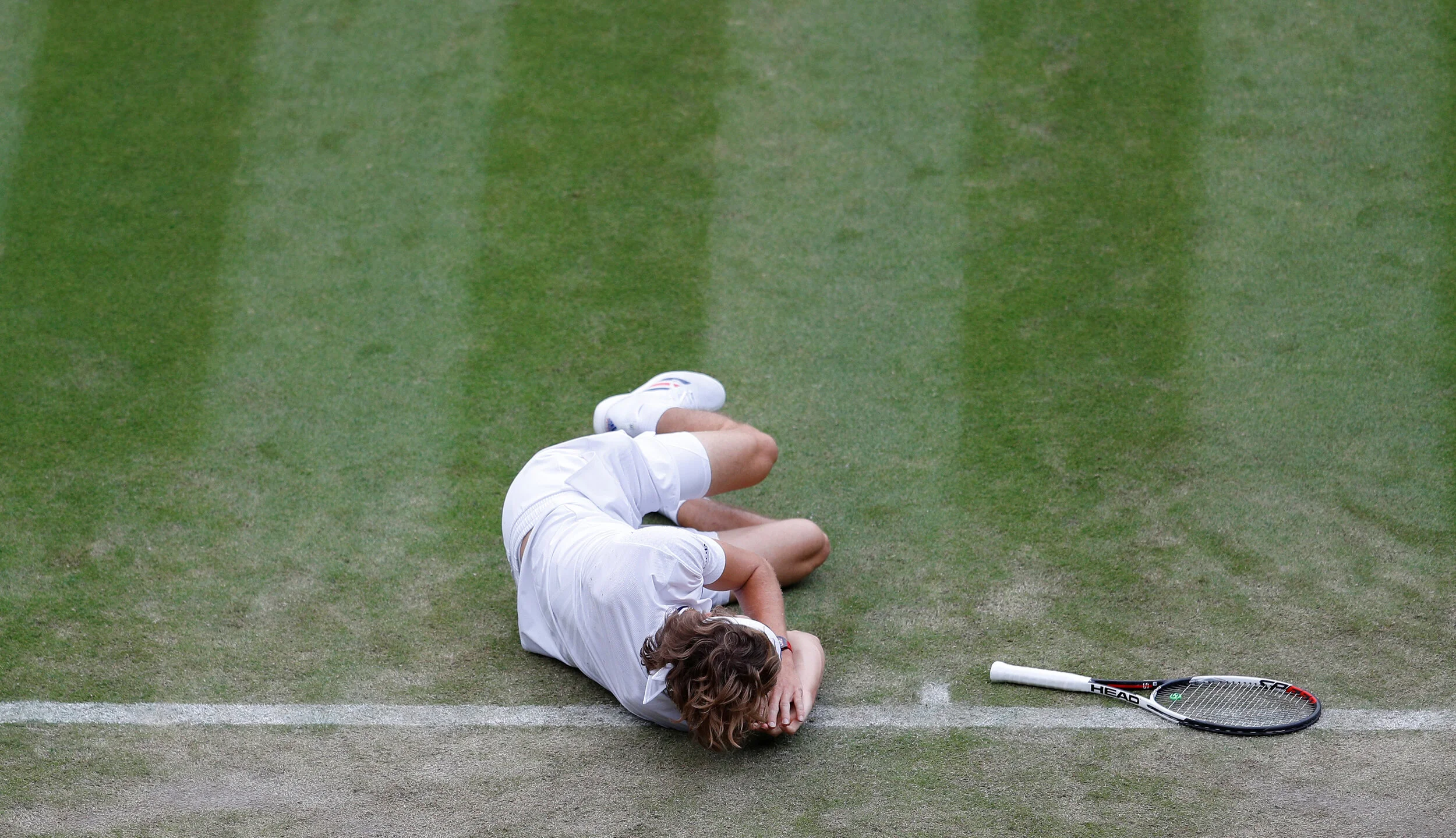  Germany's Alexander Zverev lies on the court after slipping during his second round match against Taylor Fritz of the U.S. Wimbledon - All England Lawn Tennis and Croquet Club, London, Britain - July 5, 2018.  