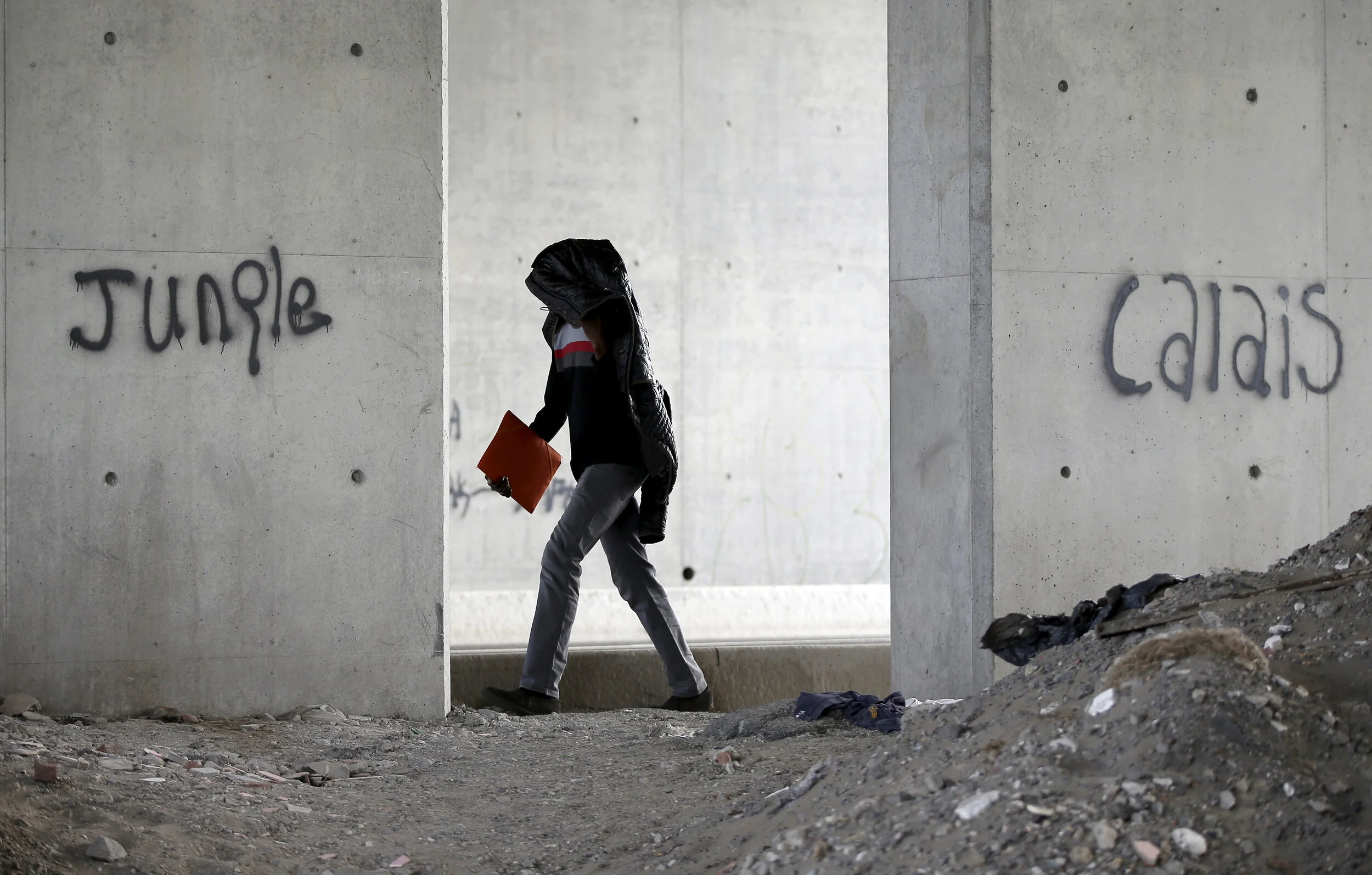  A migrant walks toward "The New Jungle" camp in Calais, France, August 4, 2015 