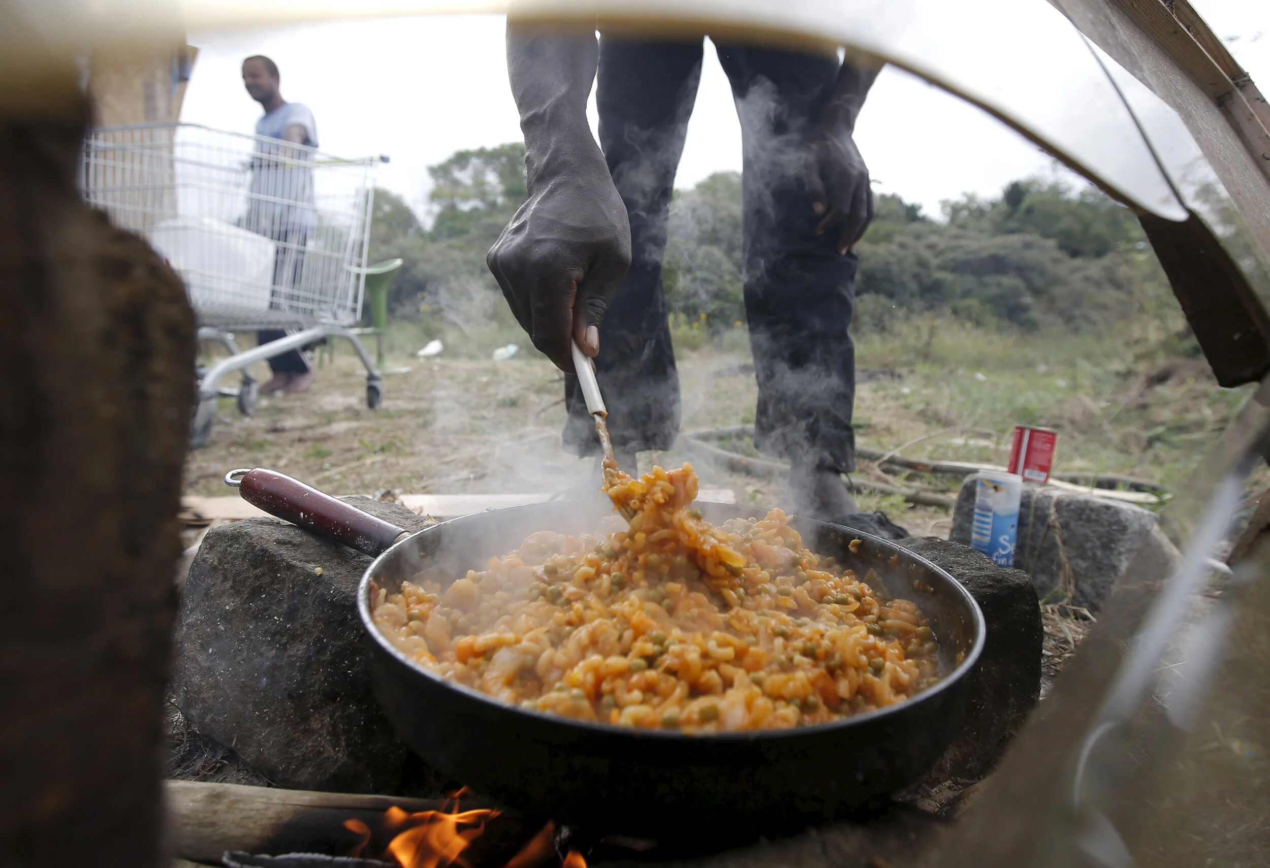  A migrant prepares food next to his temporary shelter at "The New Jungle" in Calais, France, August 6, 2015 