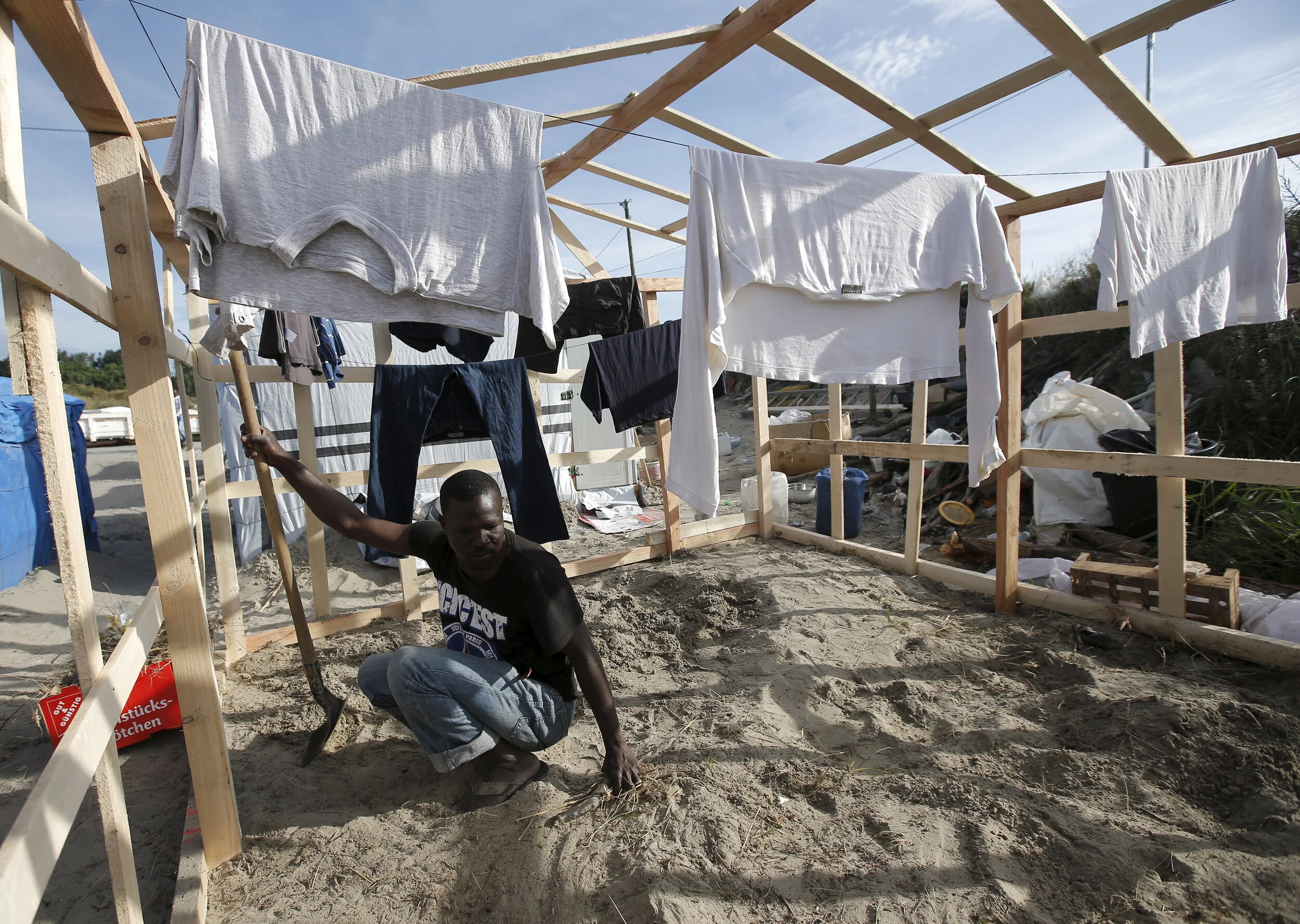  A migrant from Sudan works on his temporary shelter at "The New Jungle" in Calais, France, August 6, 2015 