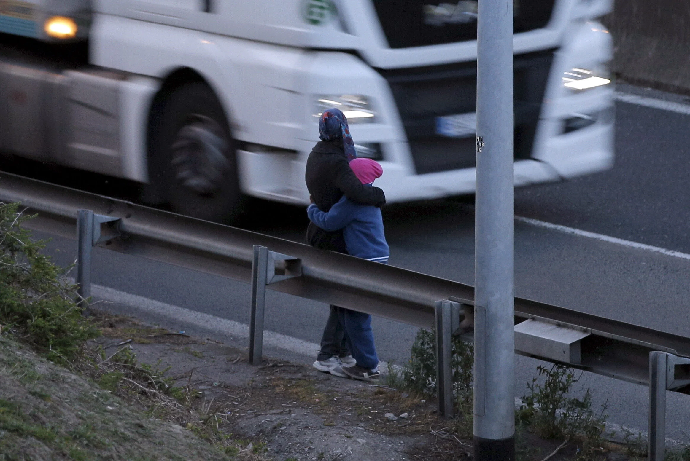  An Eritrean mother and her daughter stand alongside the motorway near the Channel Tunnel entrance near Calais, France, August 6, 2015 