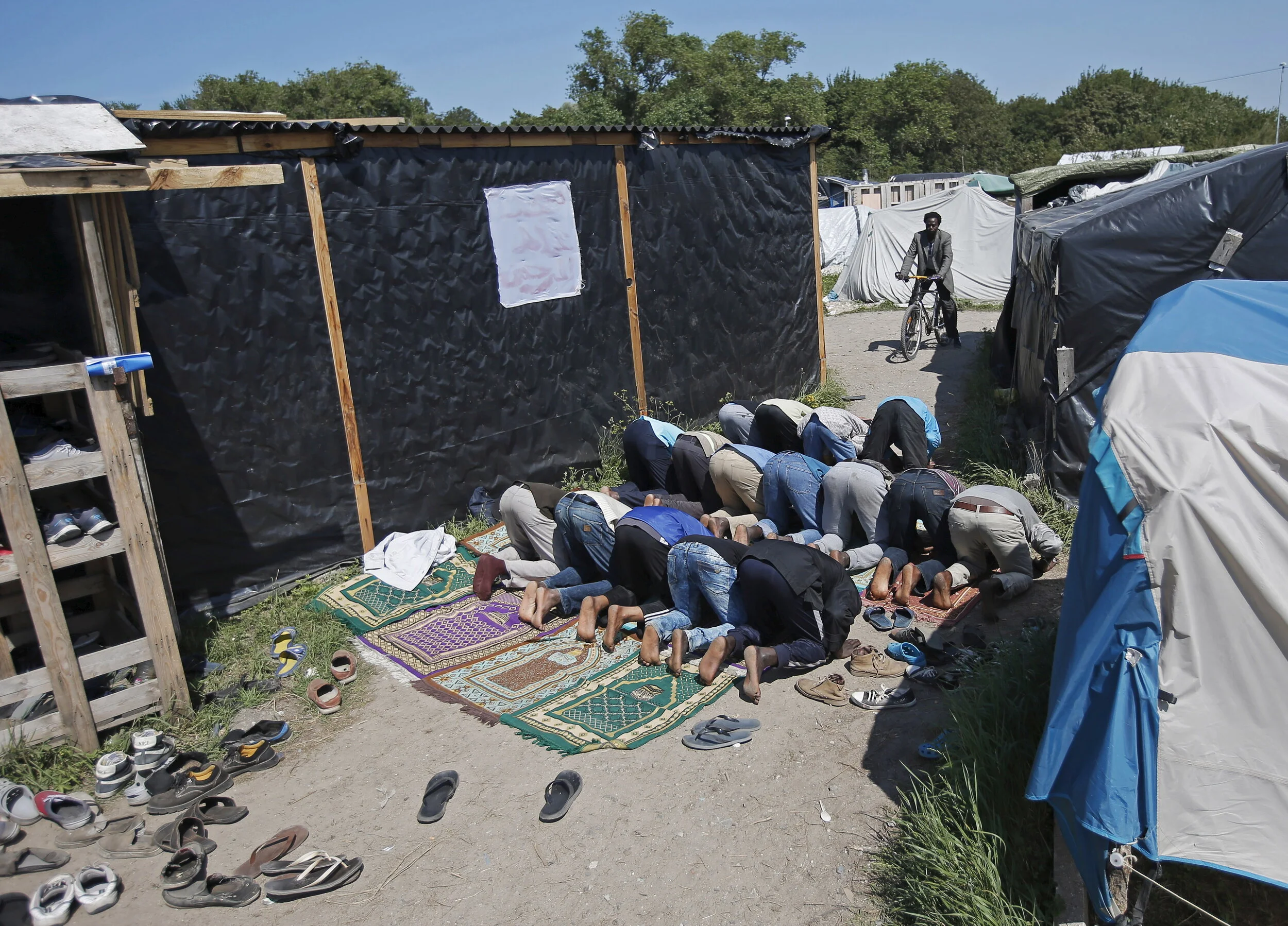  Migrants pray at a makeshift mosque in "The New Jungle" camp in Calais, France, August 7, 2015 