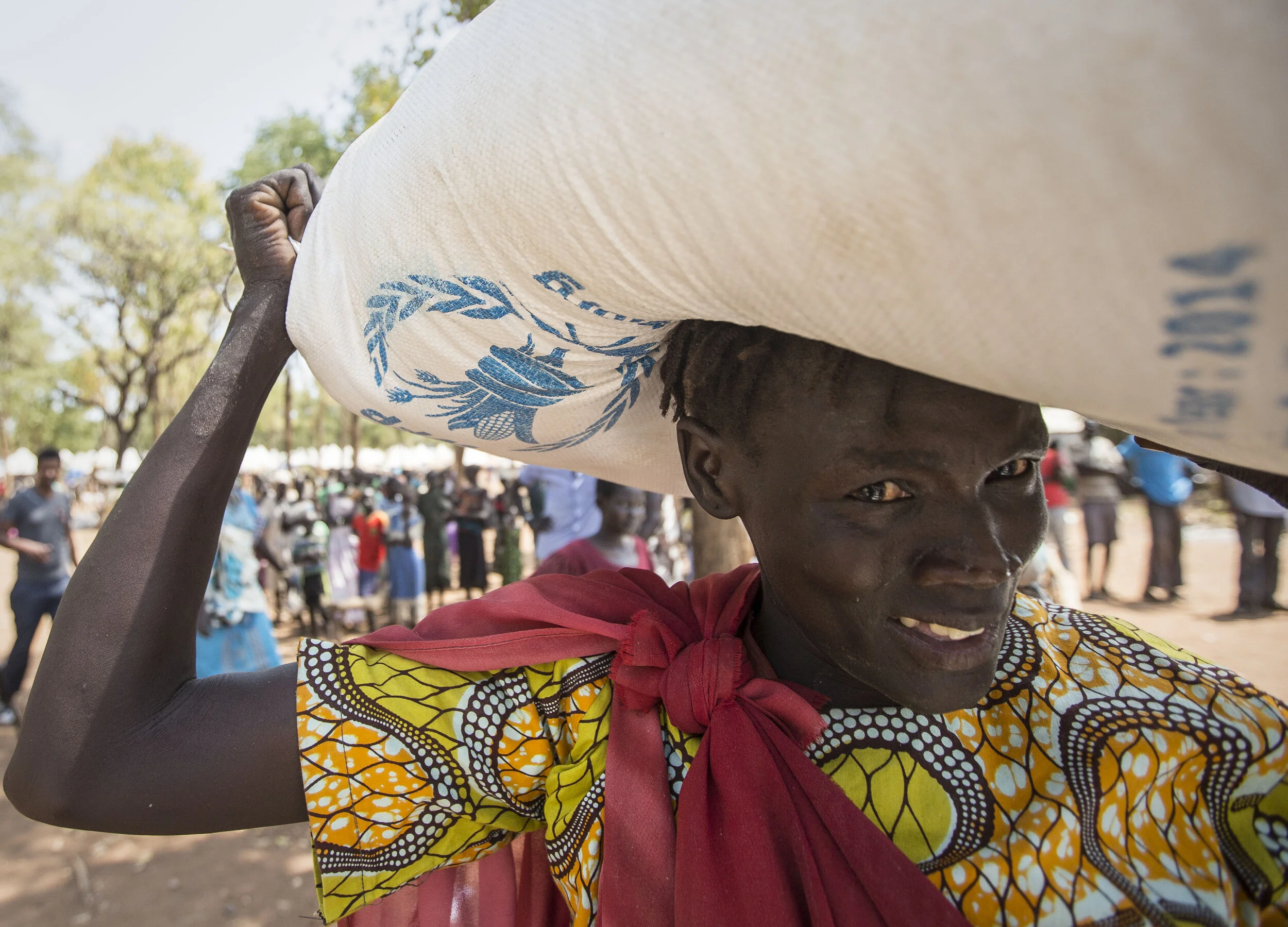  A South Sudanese woman refugee, carries a sack of maize meal food relief at the Kule refugee camp, in Ethiopia. November 7, 2014 