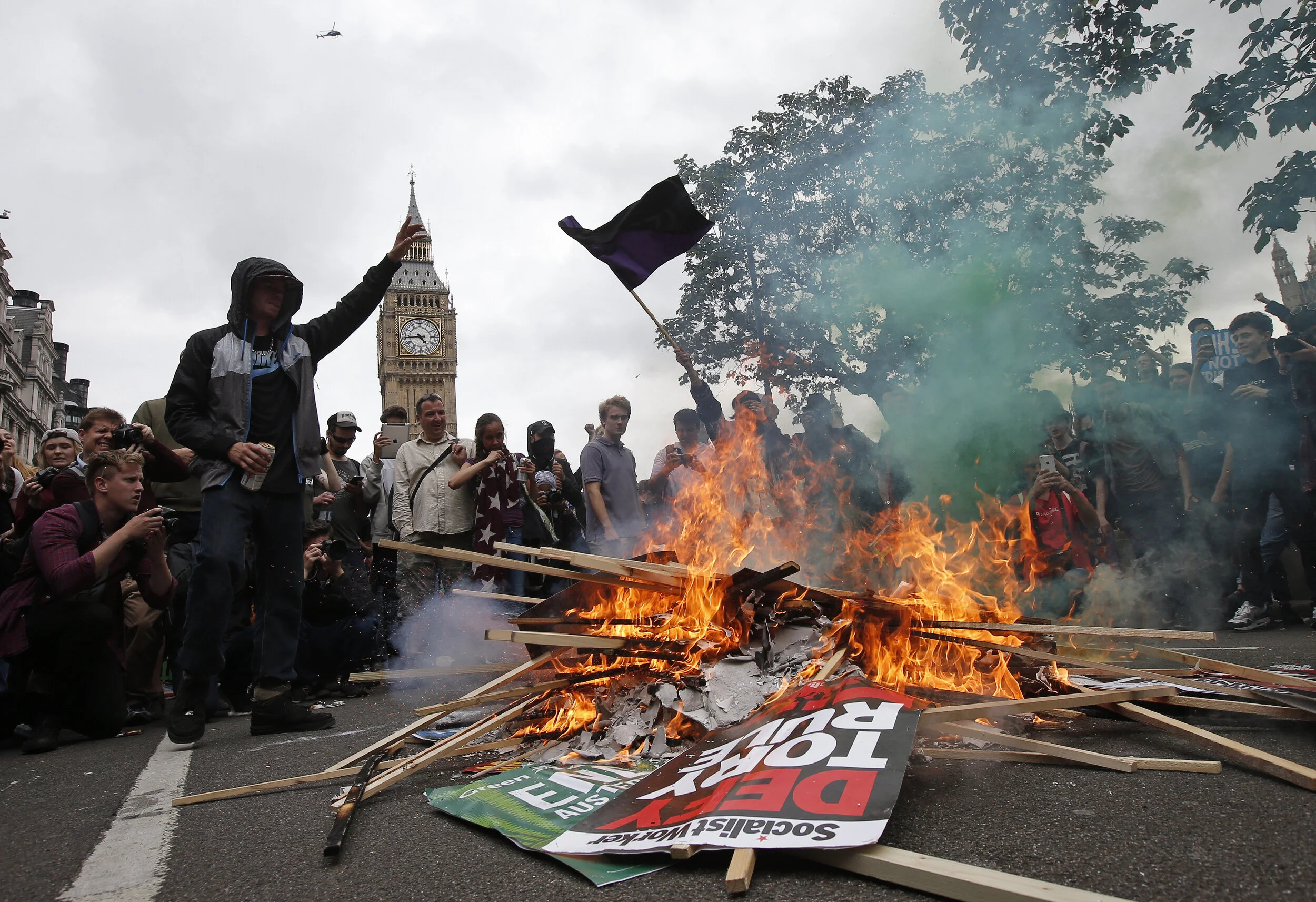  Demonstrators burn placards in front of parliament during an anti-austerity protest in central London, Britain June 20, 2015. 