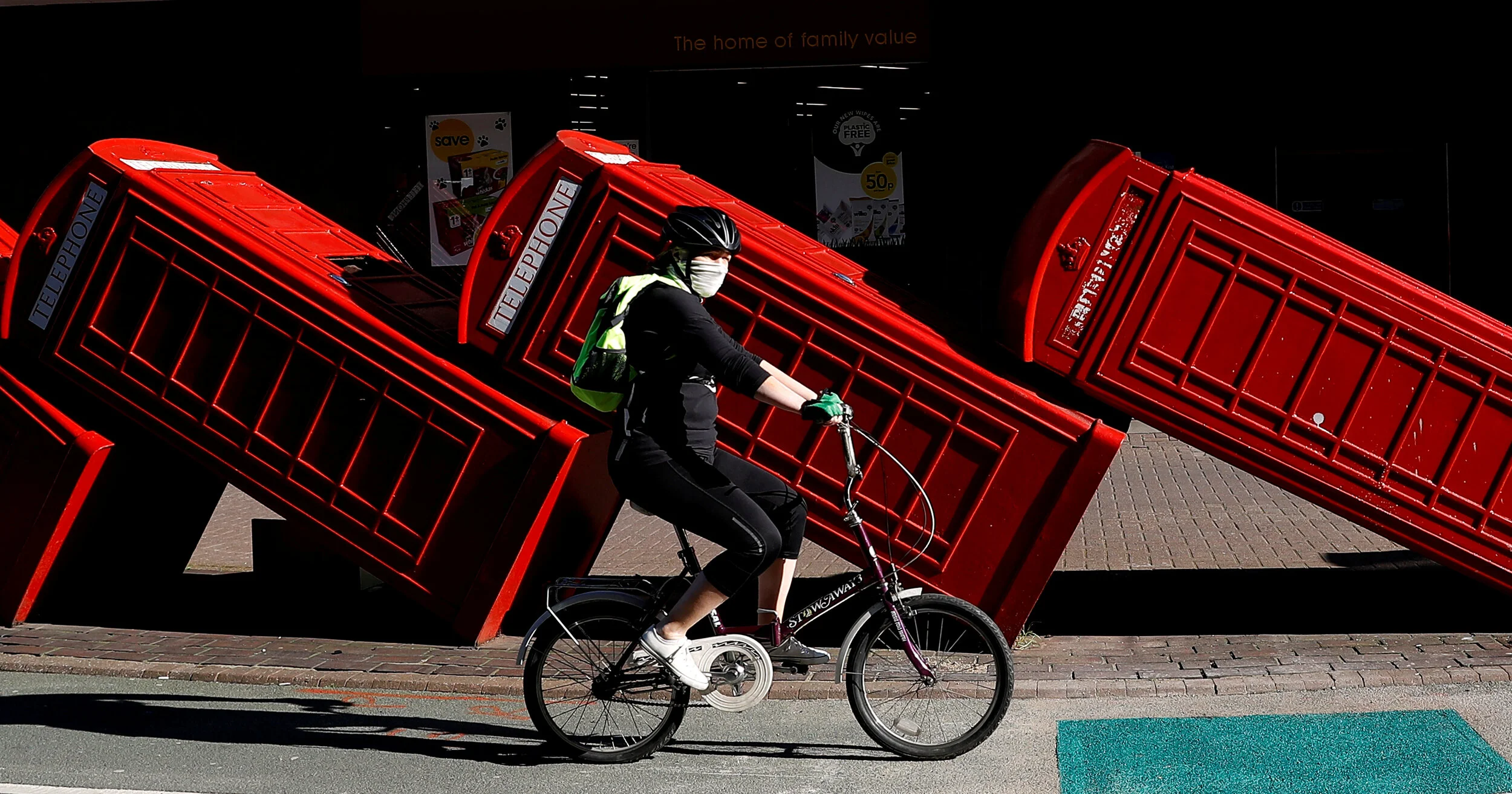  A person is seen riding a bicycle wearing face protection in front of an art installation called Out of Order while the spread of the coronavirus disease (COVID-19) continues, London, Britain, April 20, 2020.  