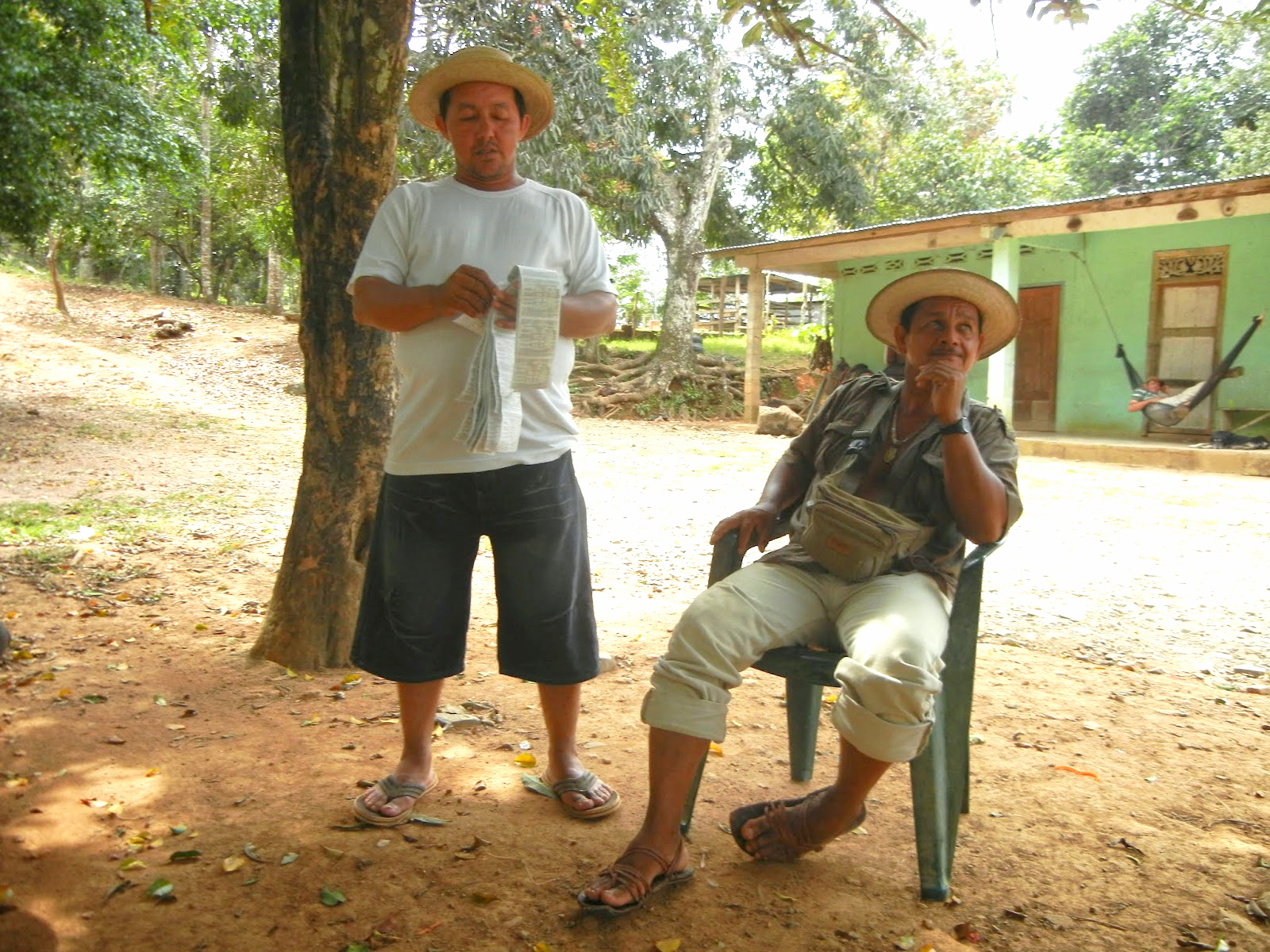 Lottery vendor Euclides takes a break from his trek while Digi peruses the numbers.