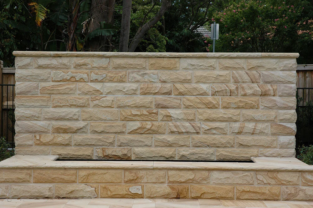 Light-medium brown sandstone colour range rock faced walling and capping water feature
