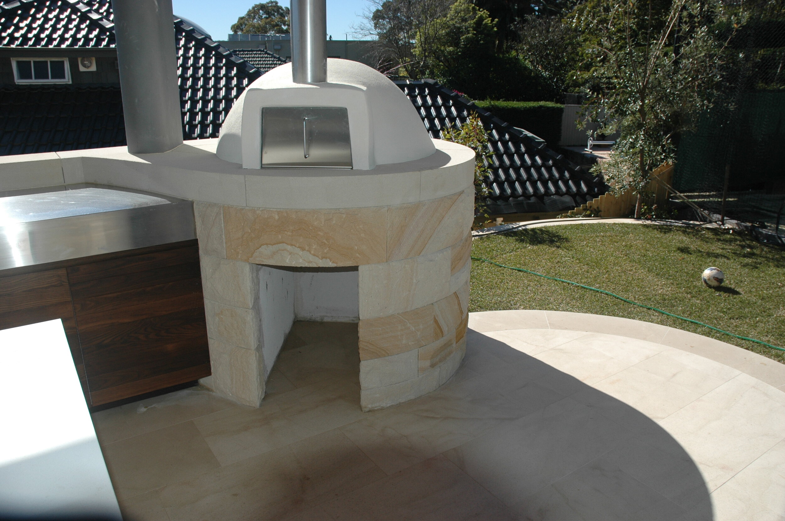 Curved sandstone cladding used for Pizza oven.