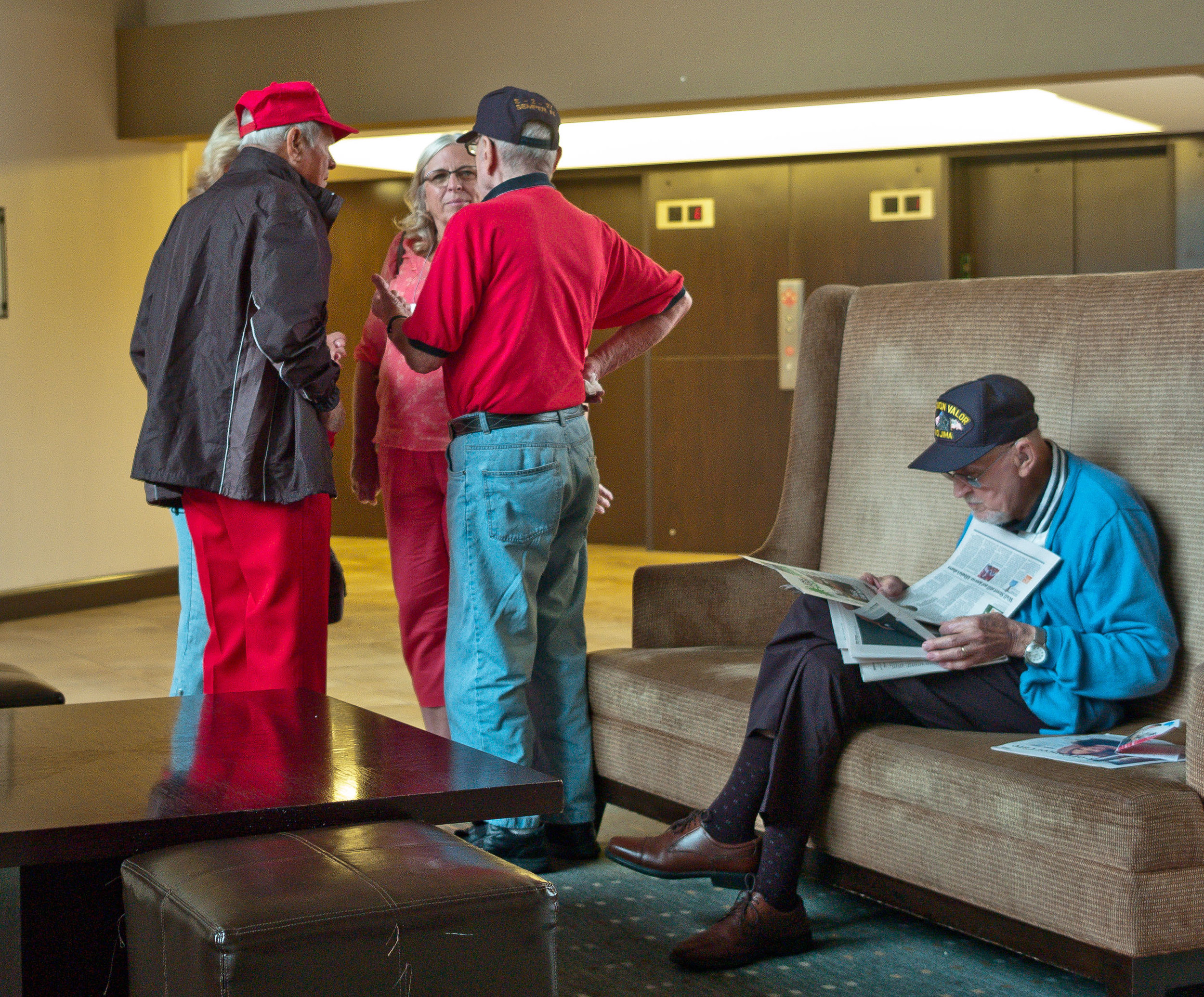 Bill Madden (seated) reading the newspaper.