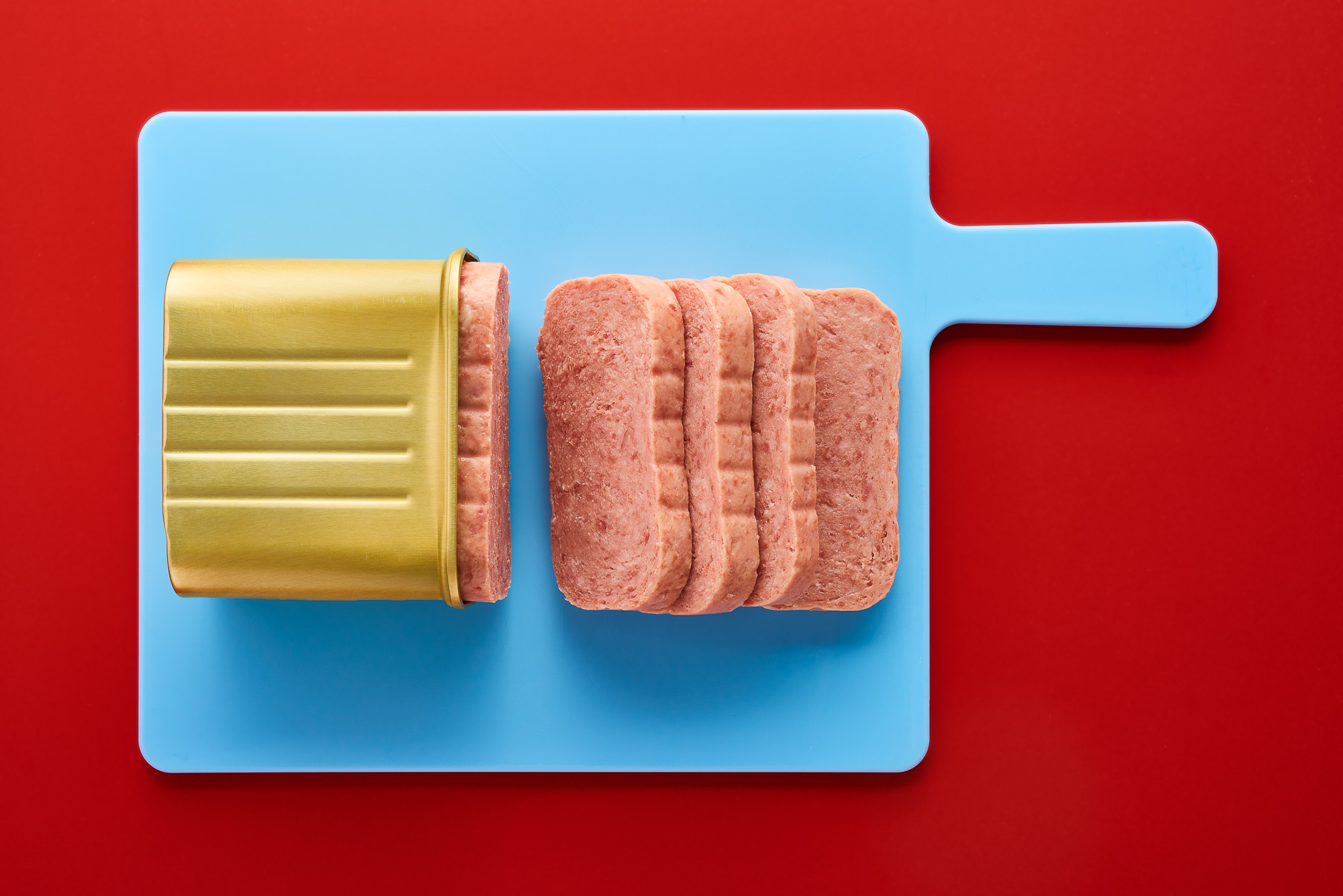 Canned processed meat on red background