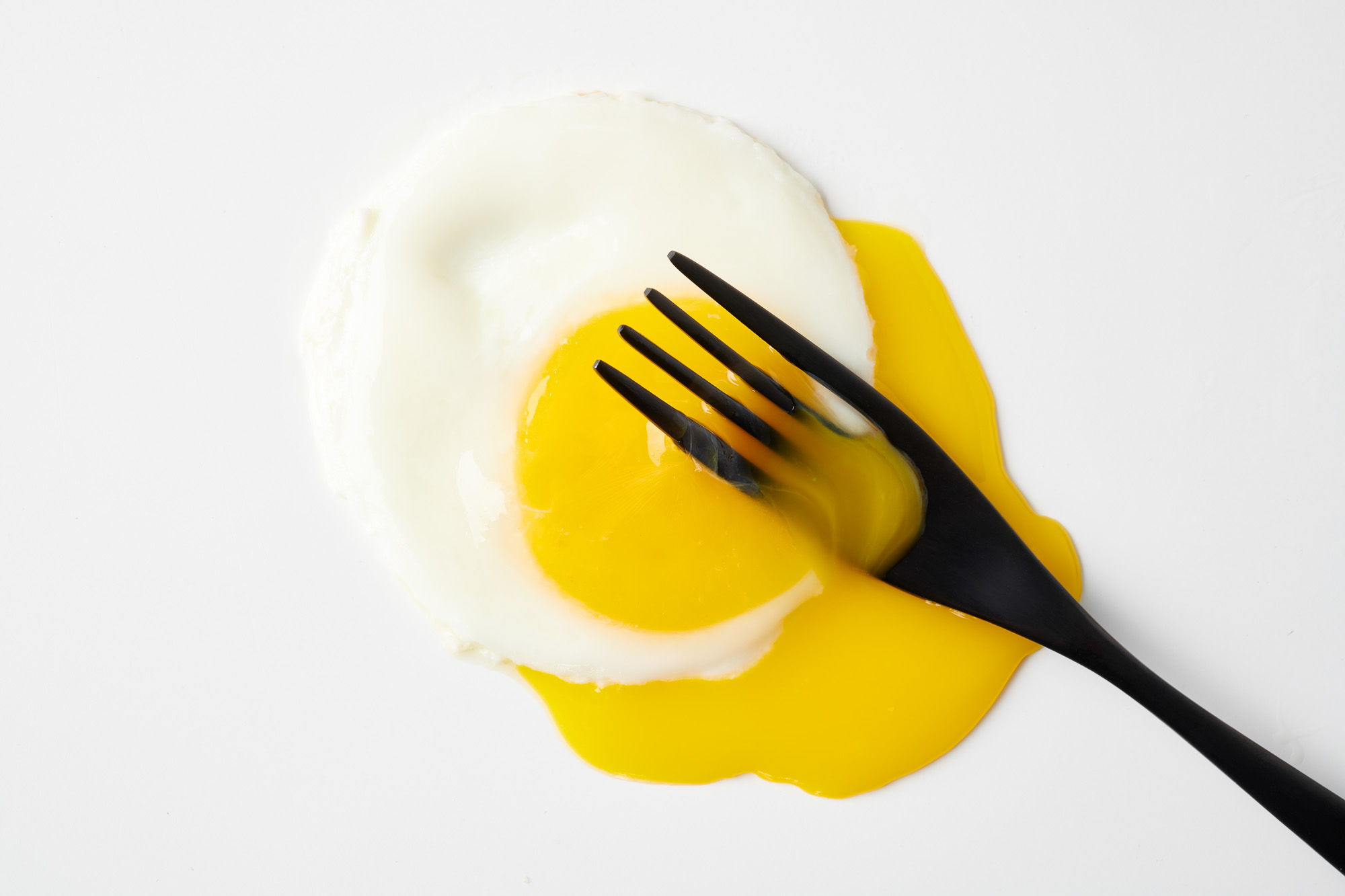 Closeup of fried egg on white