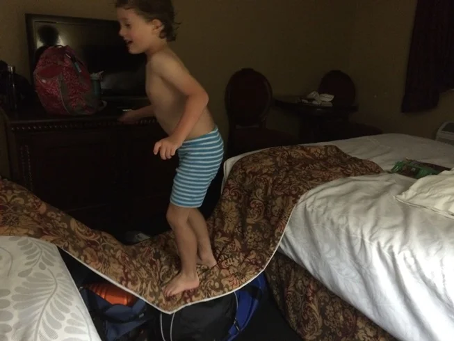 Tag making a bridge between the two beds using luggage. I guess it's better than him walking on the floor.