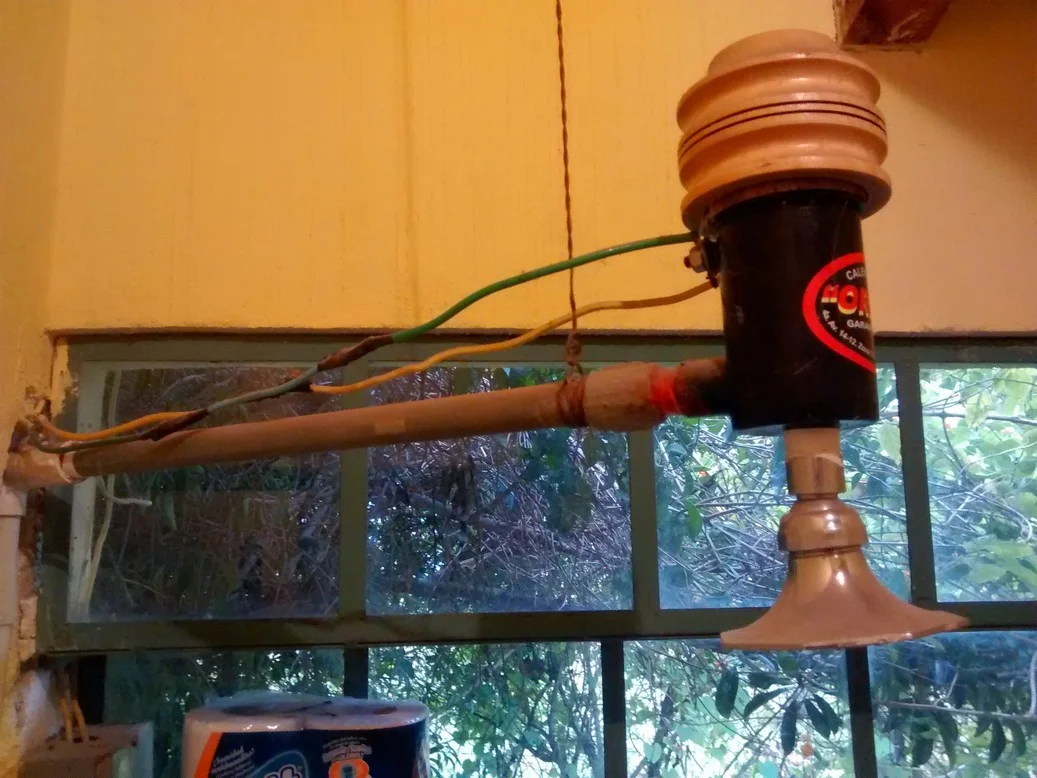 No need for a hot water heater to take warm showers with this inline electrical hot water heater (note the string holding it up).