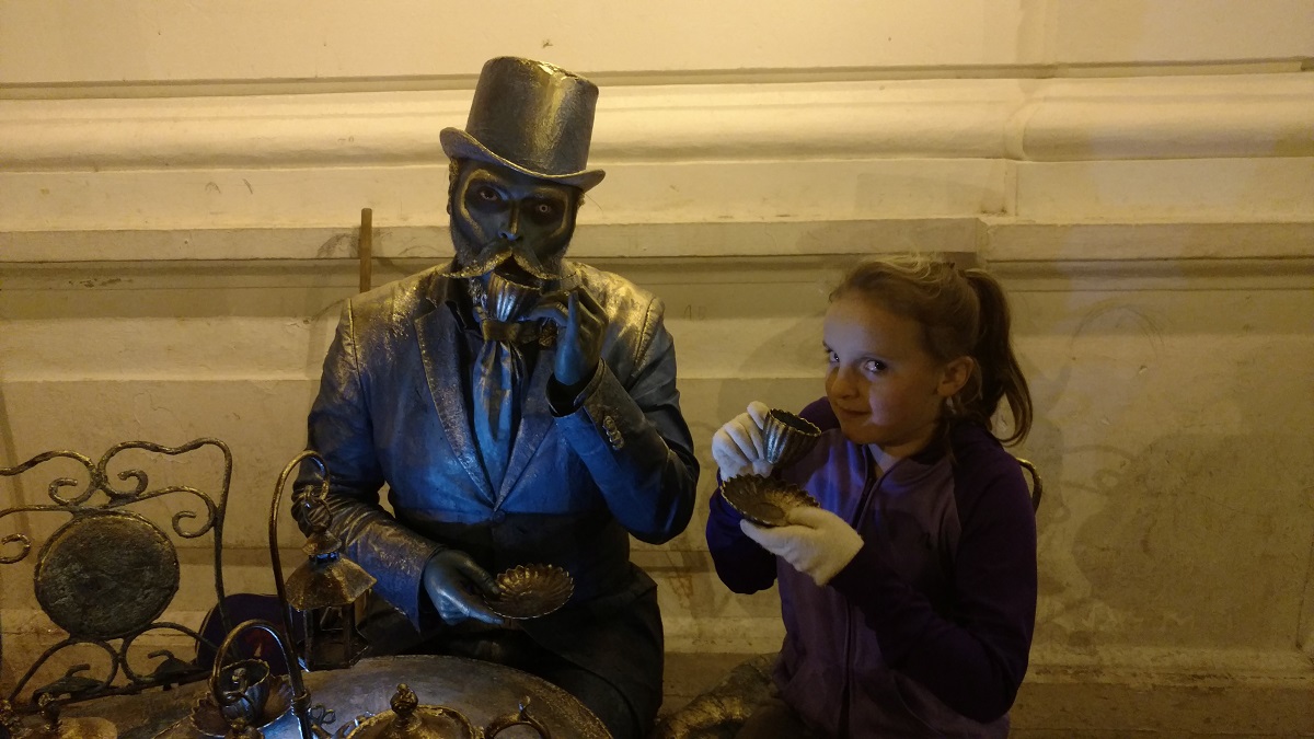 Ela having tea with a street performer.