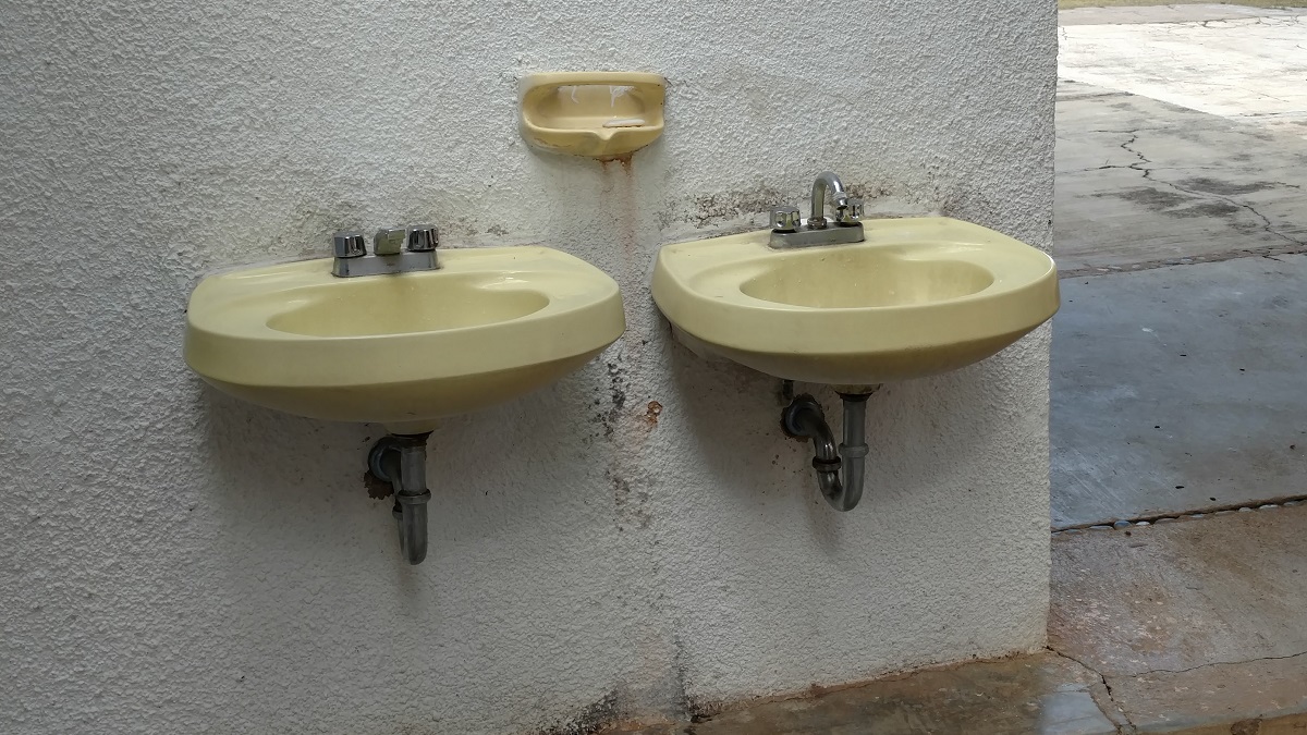 Sinks literally outside of the bathroom. Note the small bar soap but no hand towels.