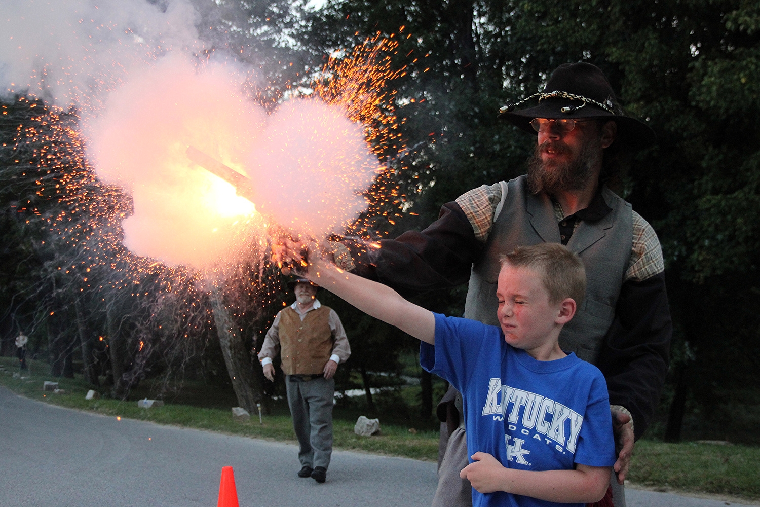   Hayden Willett, 7, of Elizabethtown, flinches during his trip through 'White Mills Then and Now' as the gunpowder in a .44-caliber Colt 1851 Navy Revolver explodes. Known as a “chain fire,” the explosion was a fairly common occurrence during the Ci