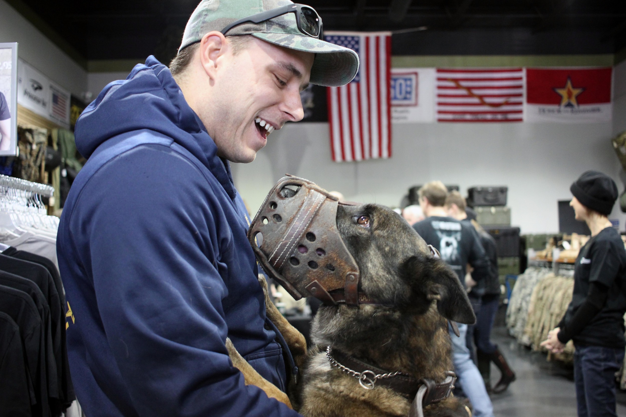   Norfolk Police Officer Adam Pascoe gives his partner, Badge, a little love after the police dog was fitted for a ballistic vest. About 40 Hampton Roads' K-9 officers were measured for the life saving gear, which they'll receive for free thanks to d