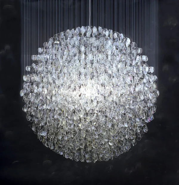 Optical (2007) by Stuart Haygarth. 
The Optical chandelier is created from over 4500 prescription spectacle lenses. The lenses are hung on monofilament line which hang from a platform. The lenses form a spherical shape which imitates a disco mirror…