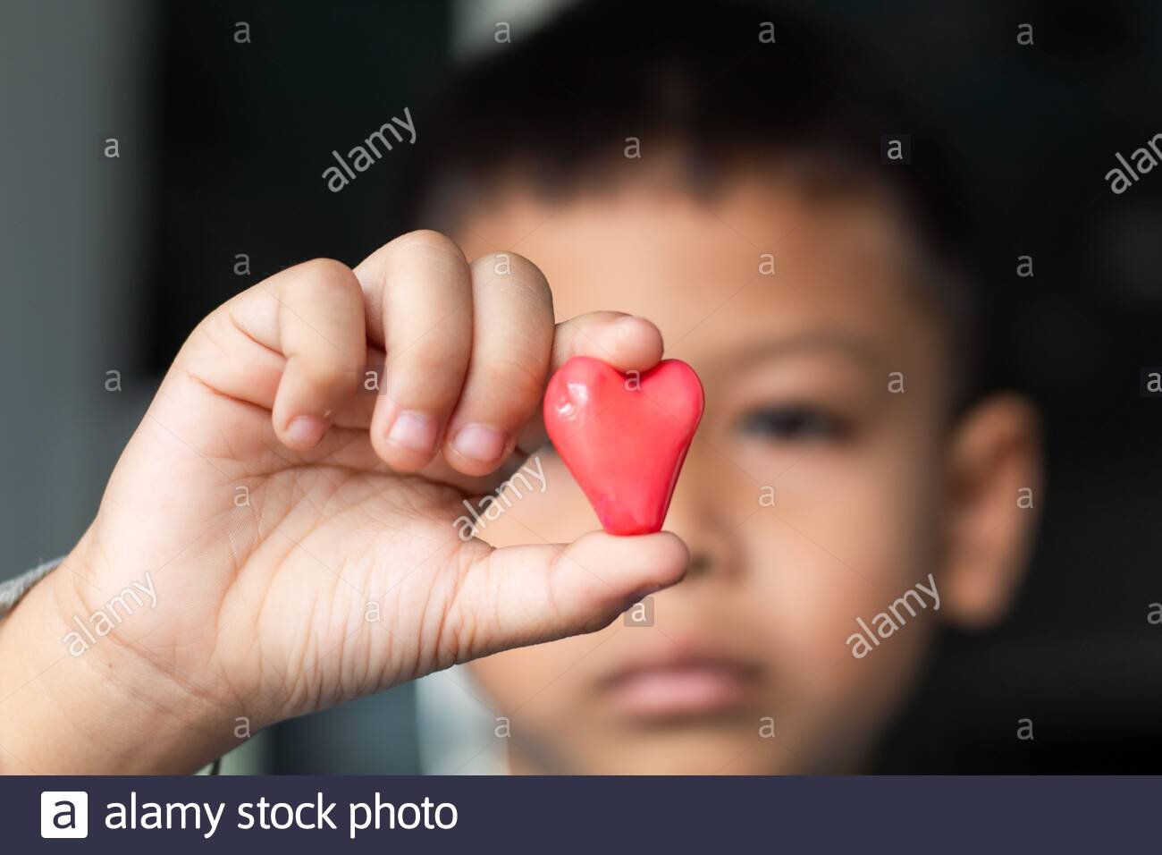 candy-red-heart-in-hand-a-boy-2BMXYT7.jpg