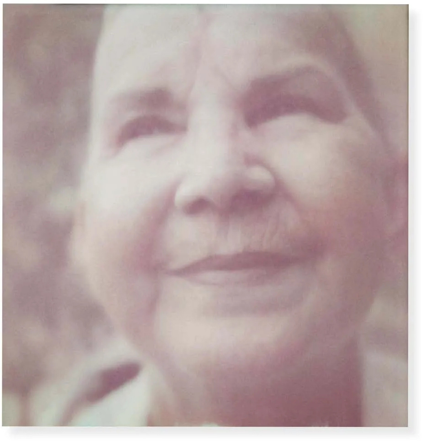 A black and white portrait of a woman smiling with her eyes closed, capturing a serene and joyful expression.