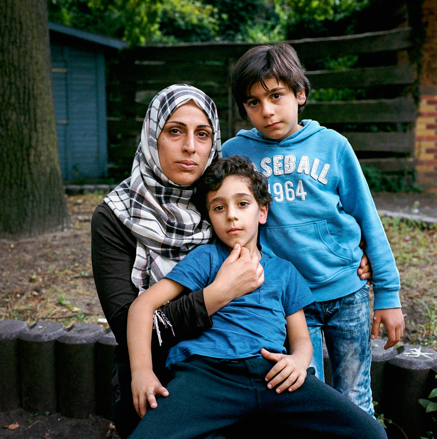 Najlaa, 40, with Mahmood, 5, and Jasan, 7 Najlaa left her small hometown near Damascus in 2011 soon after the government assaults started. She first went to Jordan with her two young children, now 5 and 7, and her nephew, also 7. She spent three years in the massive Zaatari refugee camp in Jordan, and decided to leave after a Jordan policeman suggested it would be safer she married her very young daughter off to him. Najlaa’s journey via Turkey took 3 months. She traveled in a group with 250 people but she was the only family and felt people worried she would slow things down. In Macedonia the police caught her and threatened to return her to Greece. But Najlaa was so determined and desperate, she put a knife to her throat and declared she'd rather die than trace back her journey. Surprised, the Macedonian police then helped her to the Serbian border. In Hungary a hotel owner, after taking her money, called the police on her. She arrived in Berlin in May 2015, where she now lives in a group home. Her two eldest just started school. August 22, 2015.