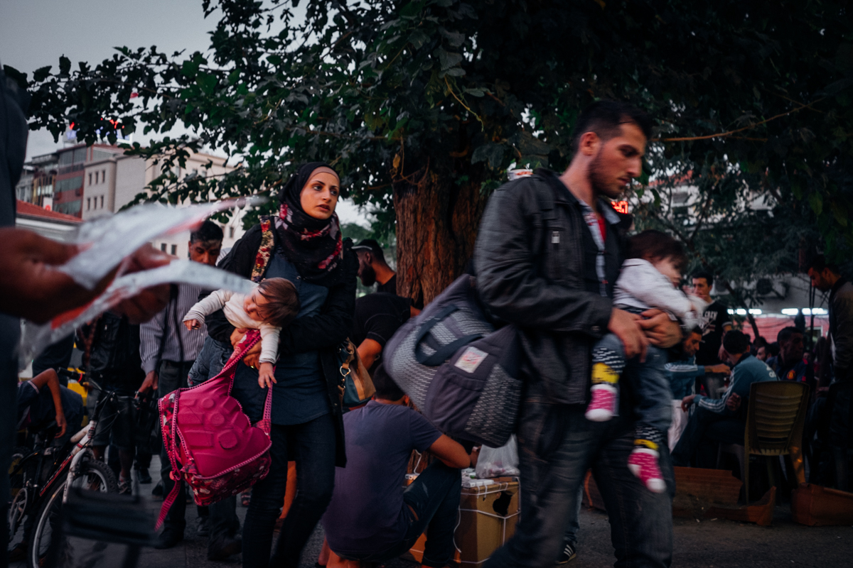 A young couple and their children rushing across Basmane Square, Izmir, a Turkish hub for refugees and smugglers alike. In this small square close the the main train station refugees and migrants connect with a smuggler to pay for a boat ride across the Aegean Sea. Boat rides were around $1,500 all through the summer of 2015. Sept 29, 2015.