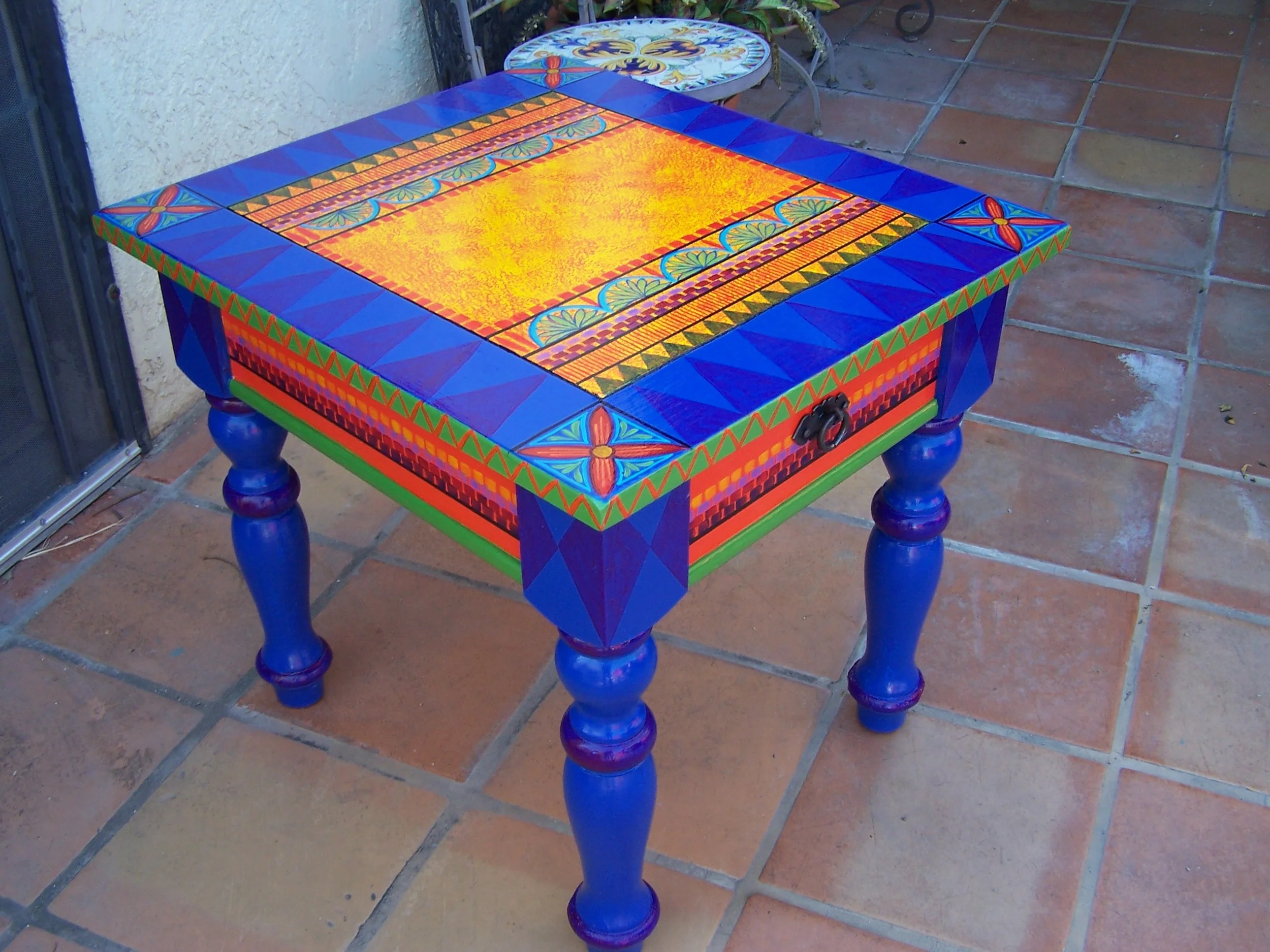  Brightly painted occasional table offers sofa-side space for drinks and books.&nbsp; 