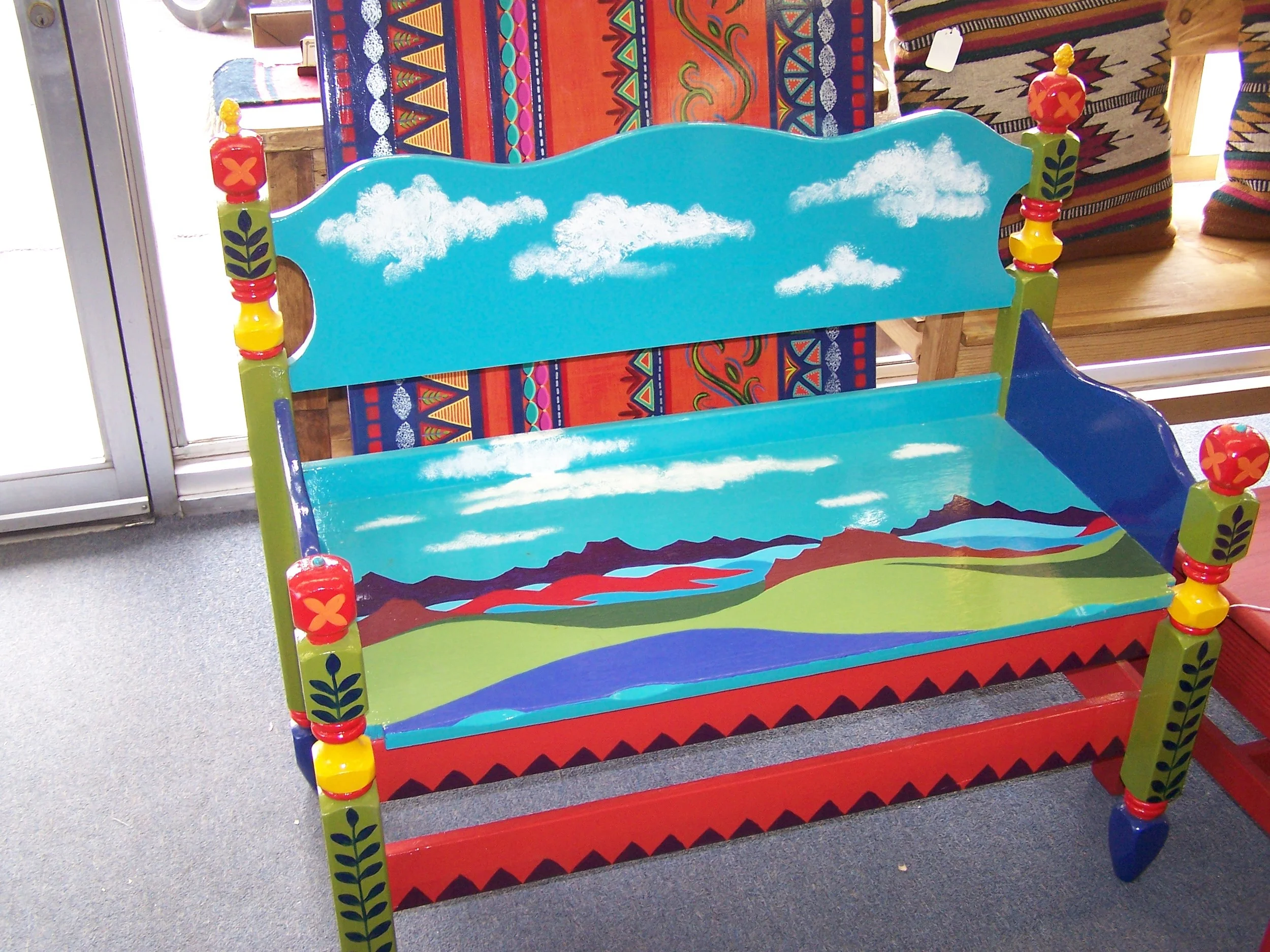  Old bench looks at home in hallway, at the foot of the bed, in he living-room. A southwestern landscape covers its back and seat. 
