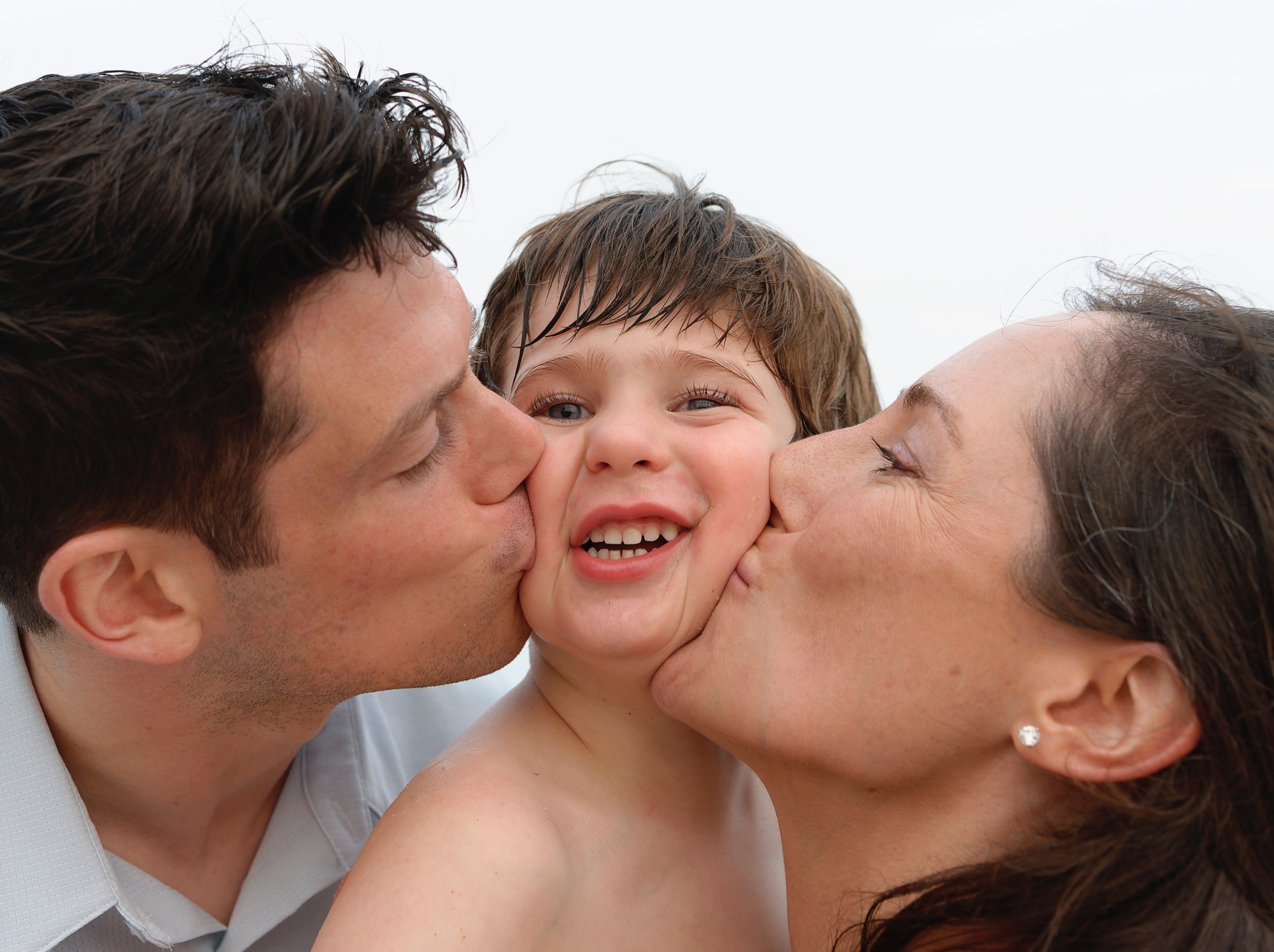 Parents kissing their smiling son