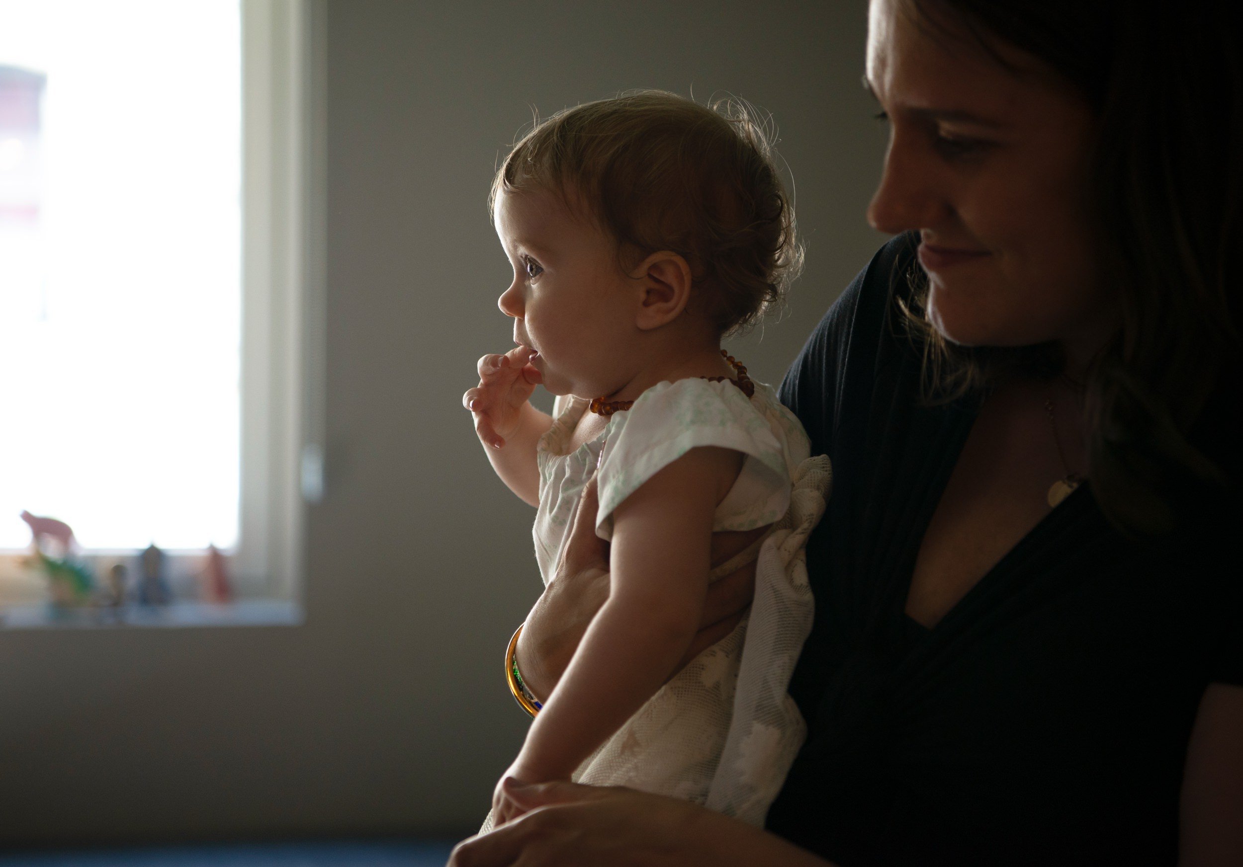 Saoirse looking toward a window while being held