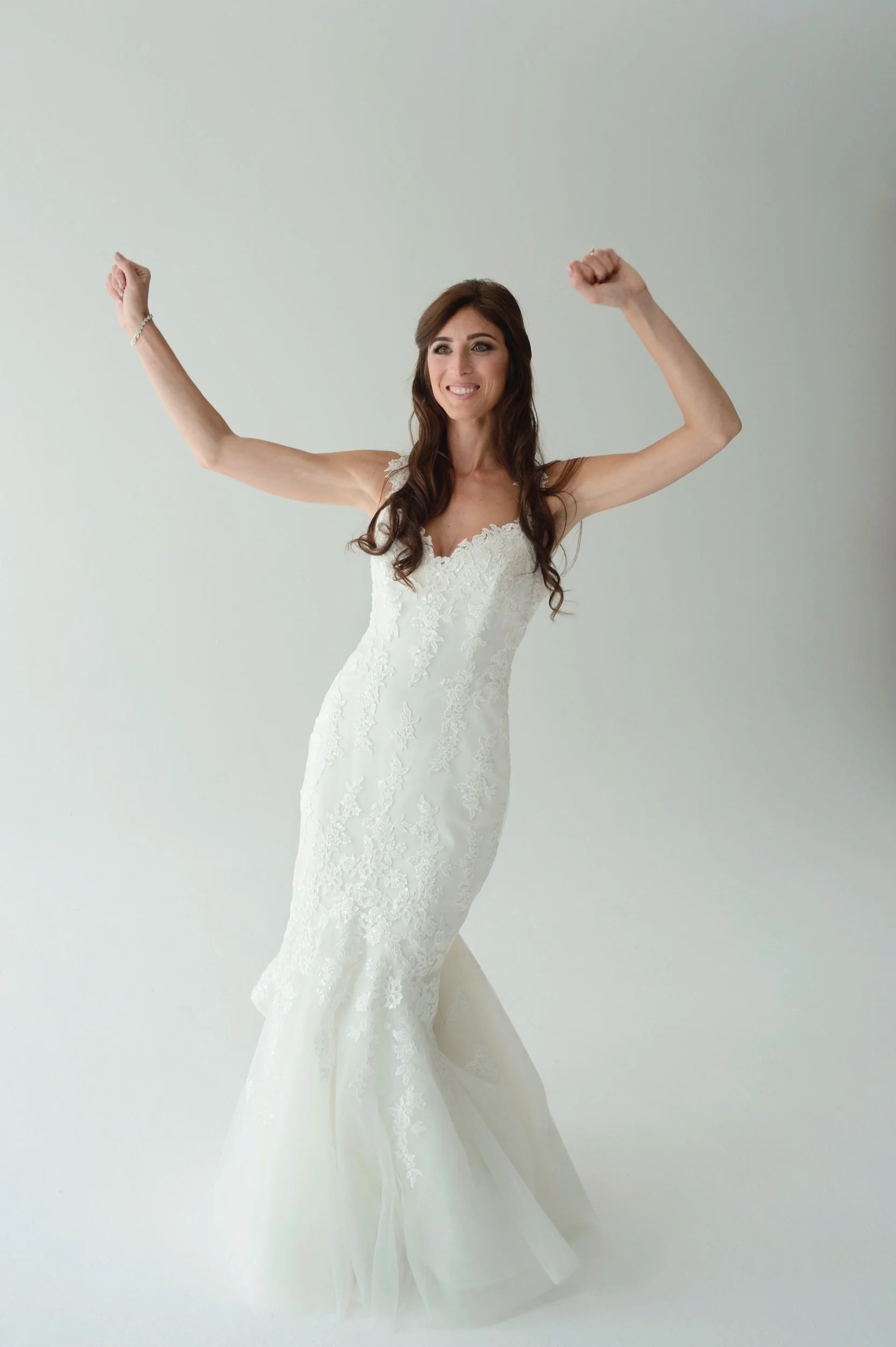 Full length candid bridal portrait in natural window light wearing Pronovias wedding dress