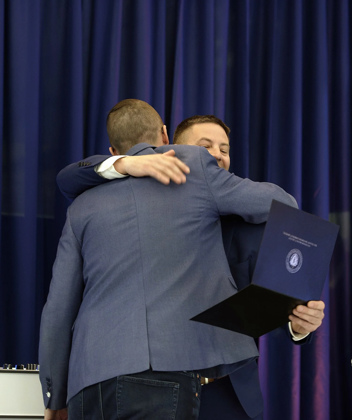 Ben Philbrook and Matthew Regan hug when presented with certificate