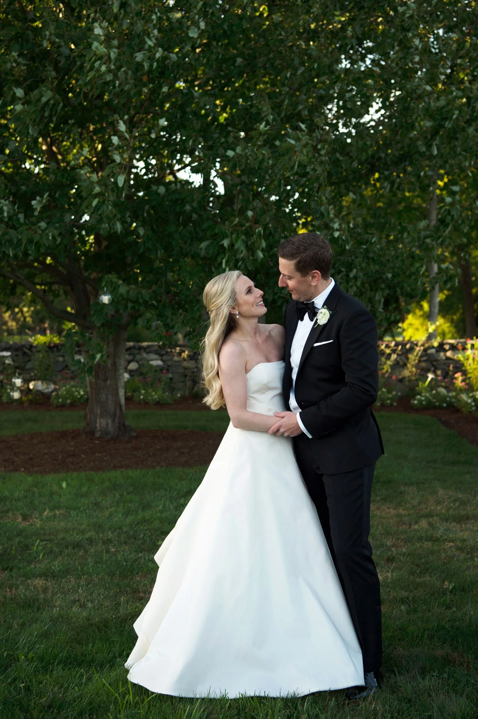 Full length portrait of bride and groom surrounded by natural greenery
