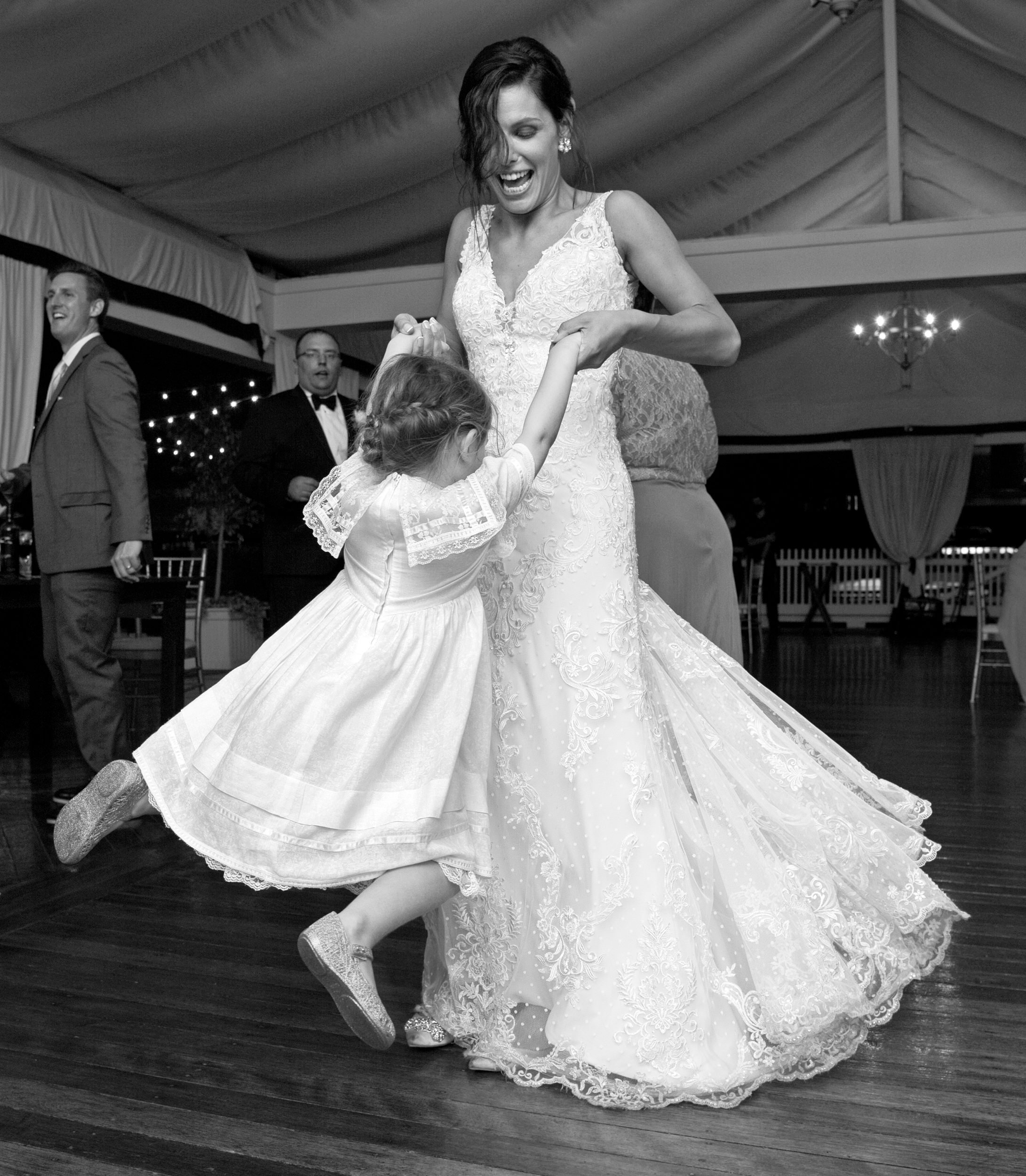 Bride twirling the flower girl on the dance floor during the reception