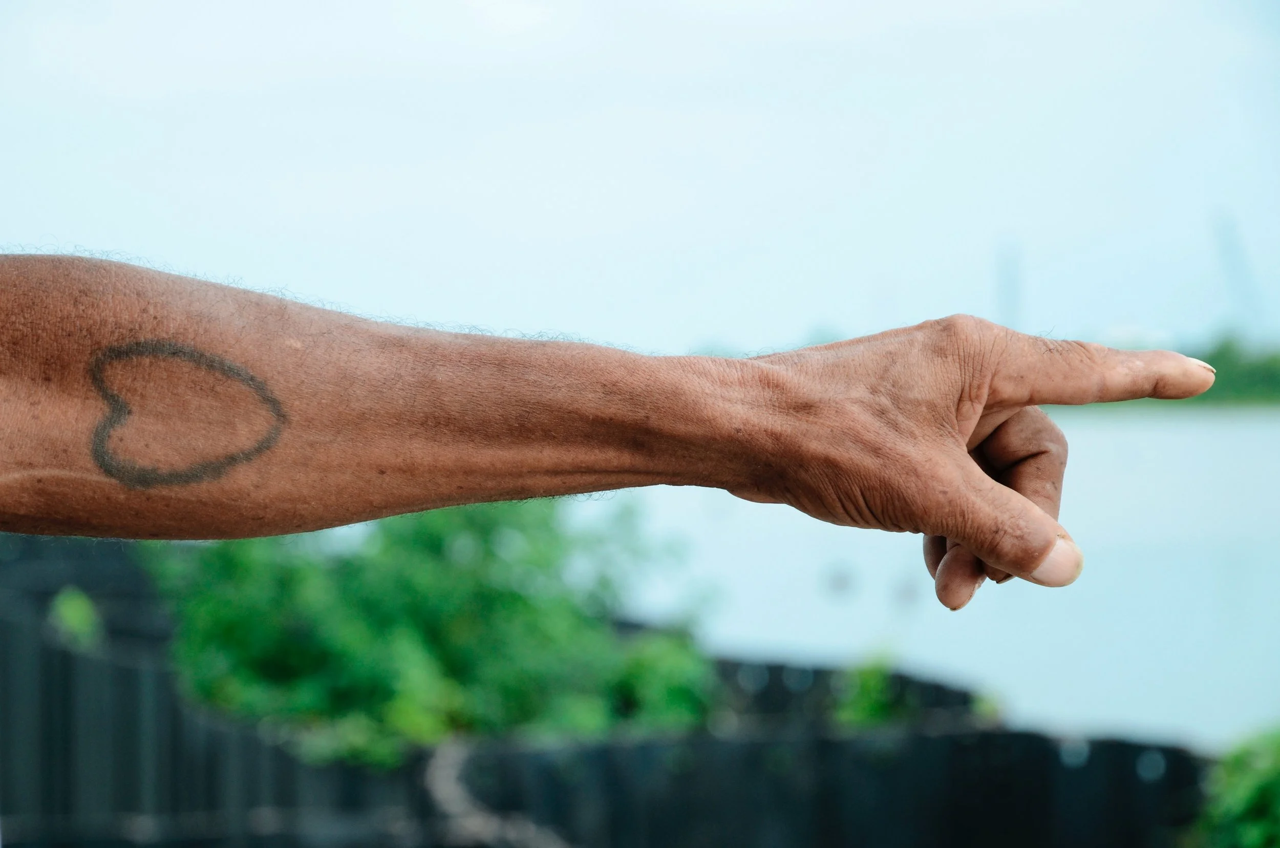 Arm with heart tattoo pointing to city of New Orleans, Louisiana