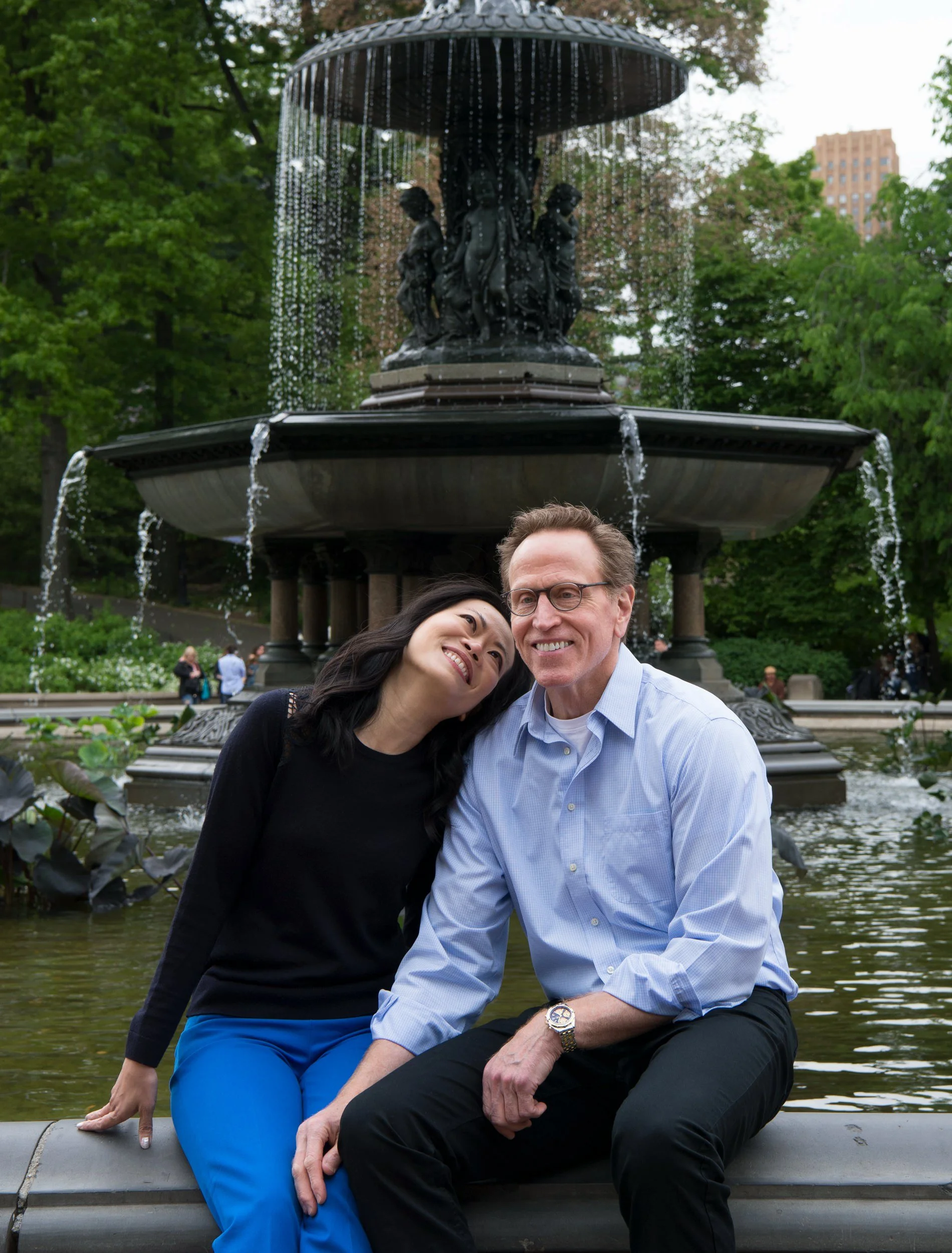 Helen and Paul smiling together in front of Bethesda Fountain in Central Park.