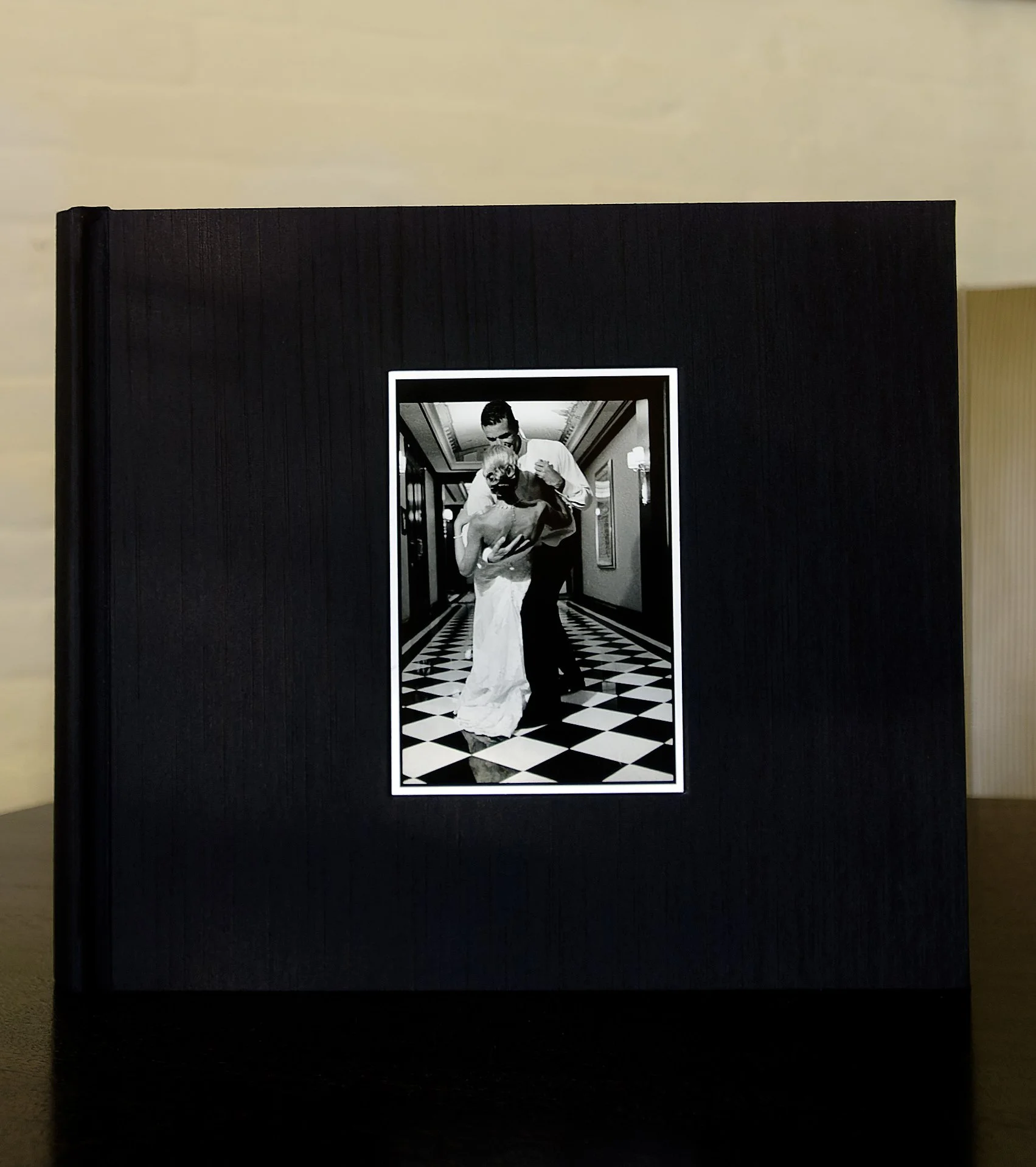 Black silk album with a portrait photograph of bride and groom
