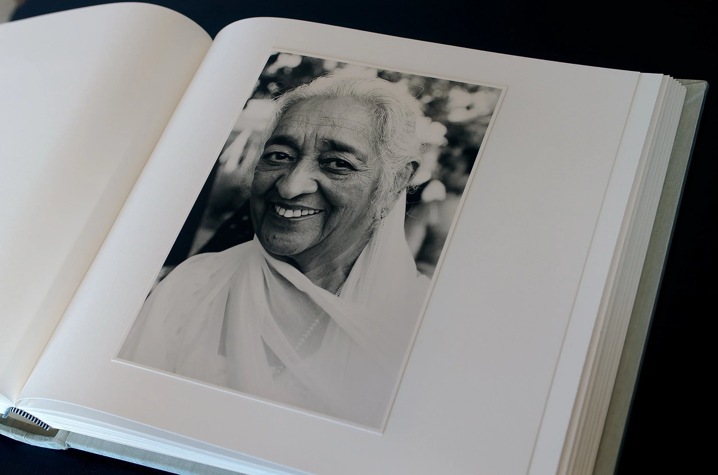 Open album with black & white hand printed fiber-based photograph hand-mounted onto page