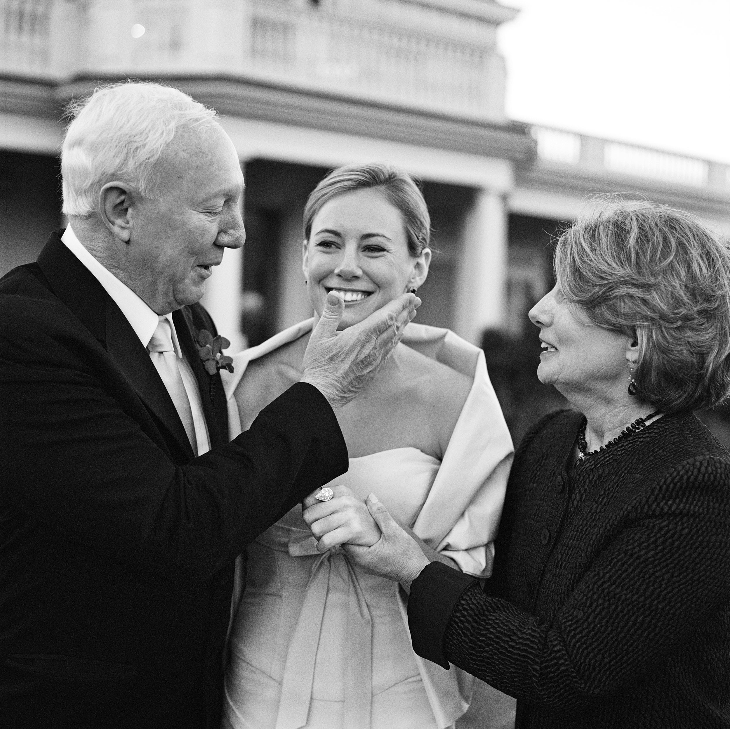 Black and white film photo of bride with her parents.
