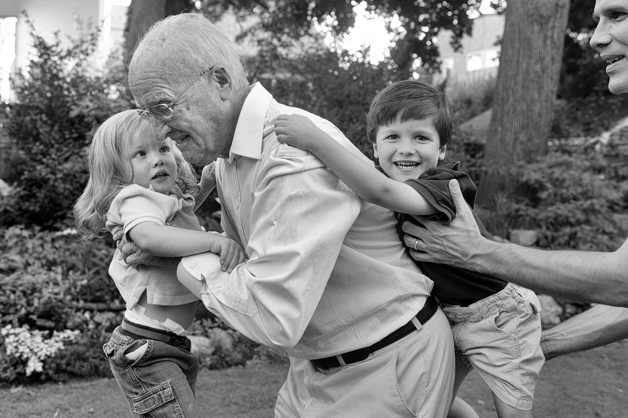 Two grandsons climbing on grandpa during an extended family portrait session in Providence