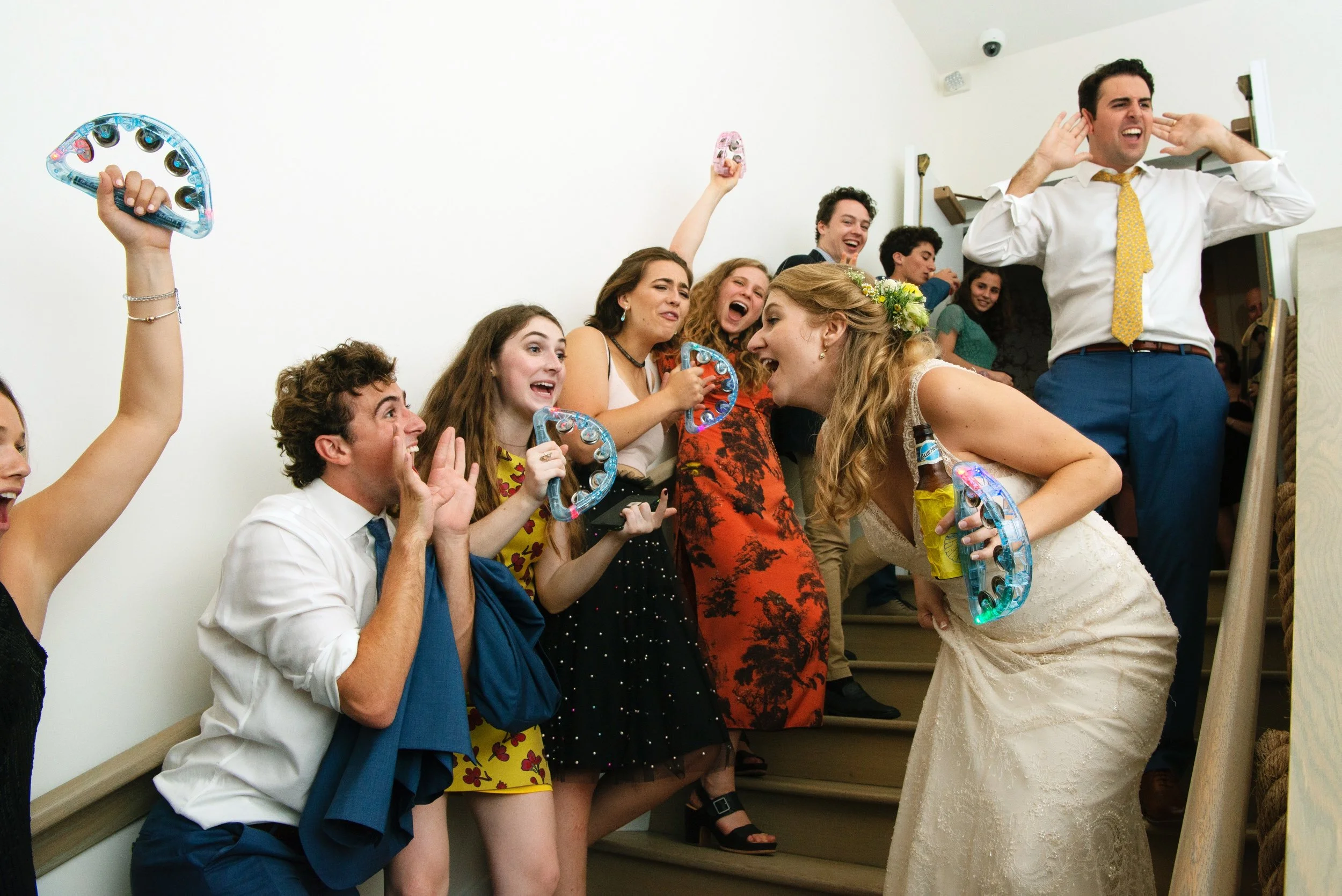Bride and groom walk down stairs being cheered by guests