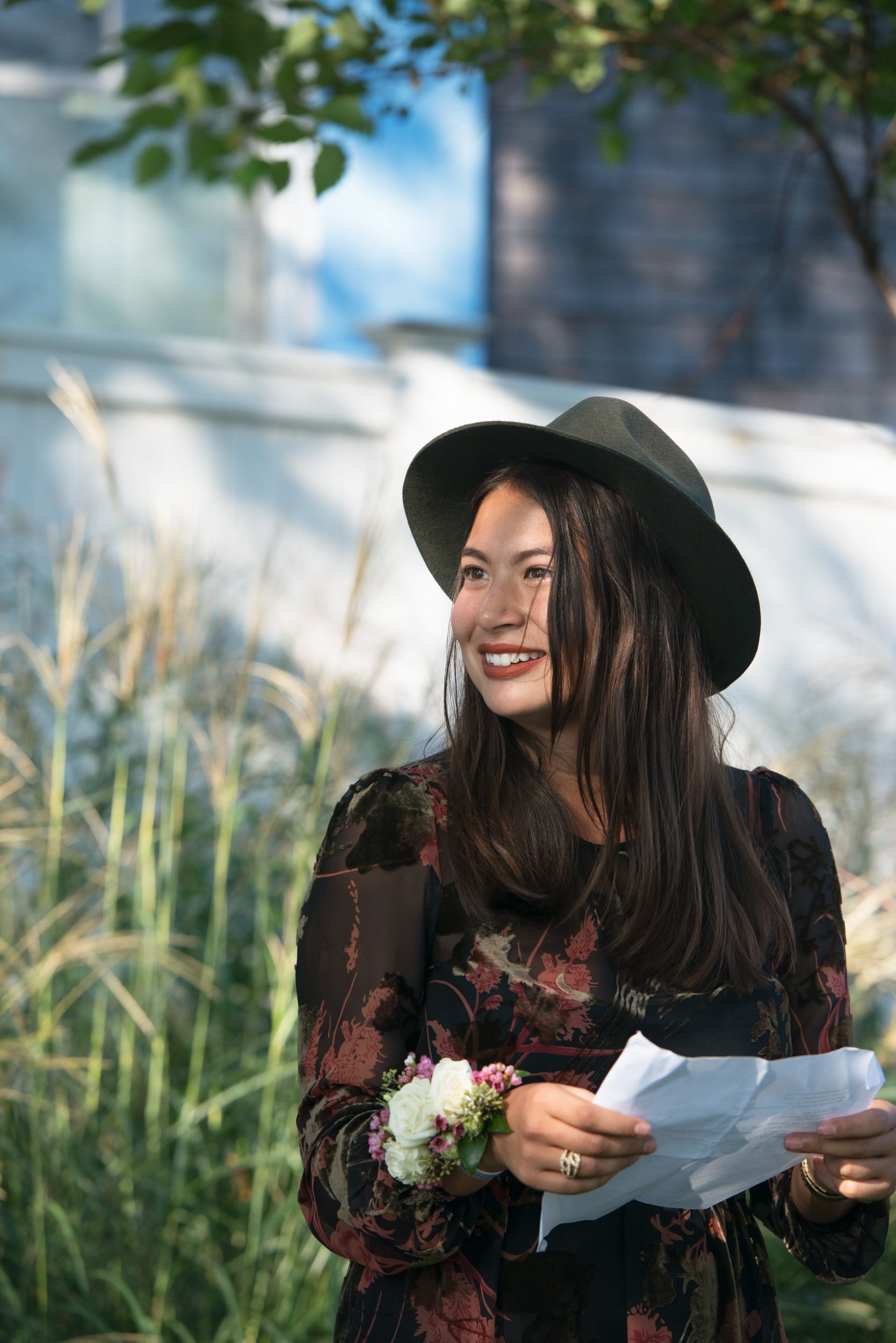 Wedding guest reading to brides during the ceremony