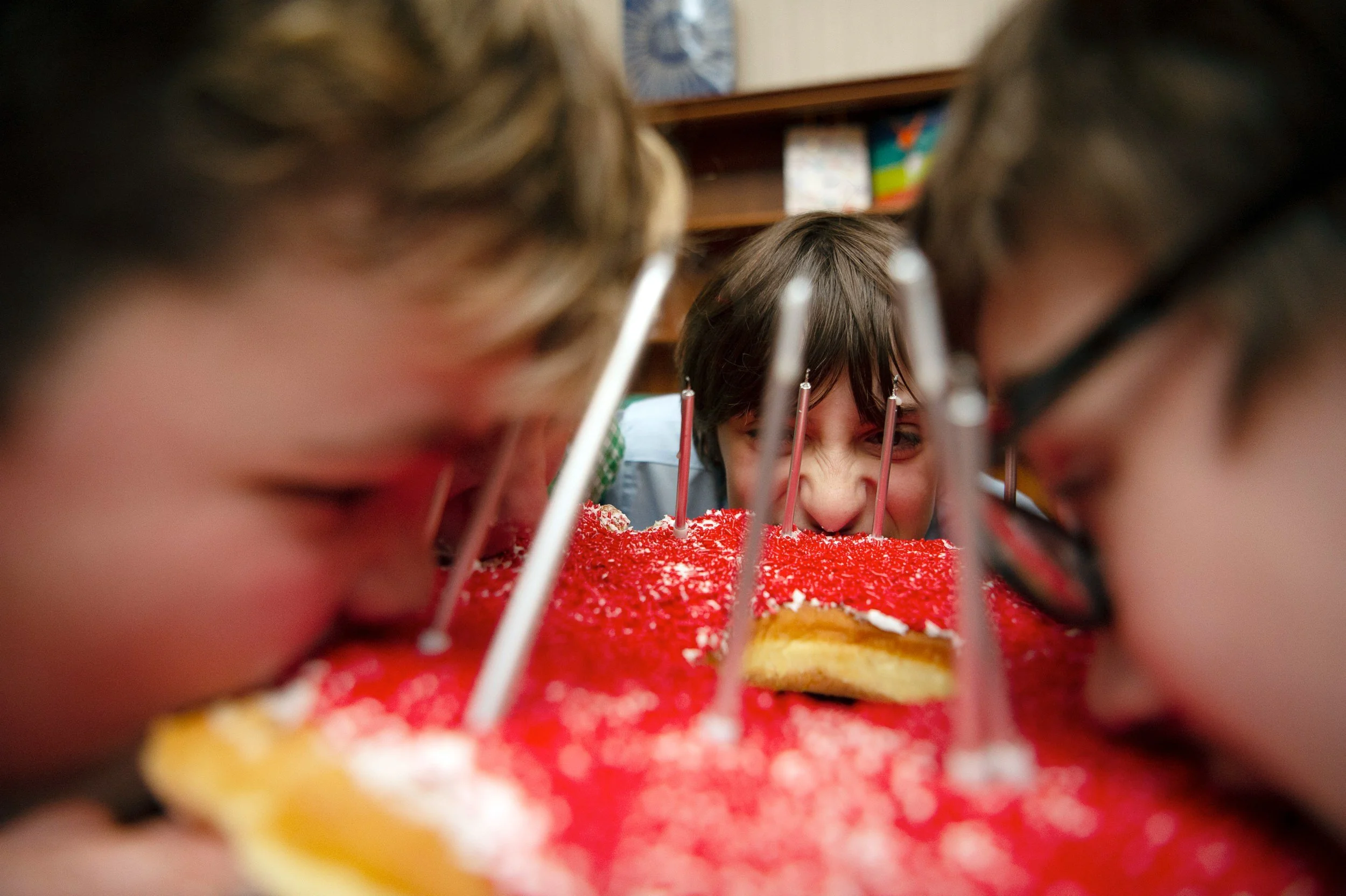 Friends take bite of giant donut cake from Allie's Donuts with birthday candles