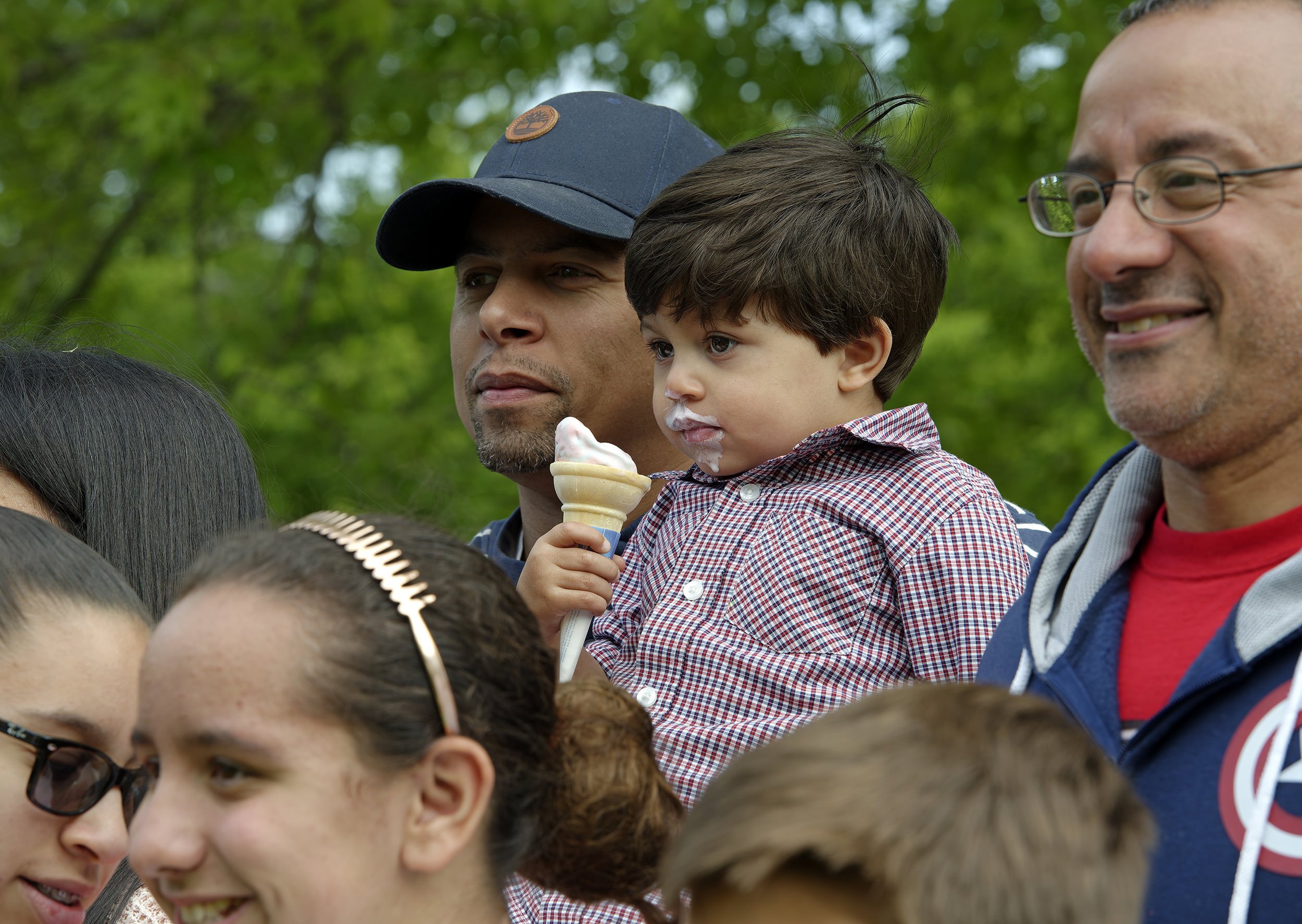 Father and son with ice cream cone during remembrance ceremony at Slater Park, Pawtucket, Rhode Island
