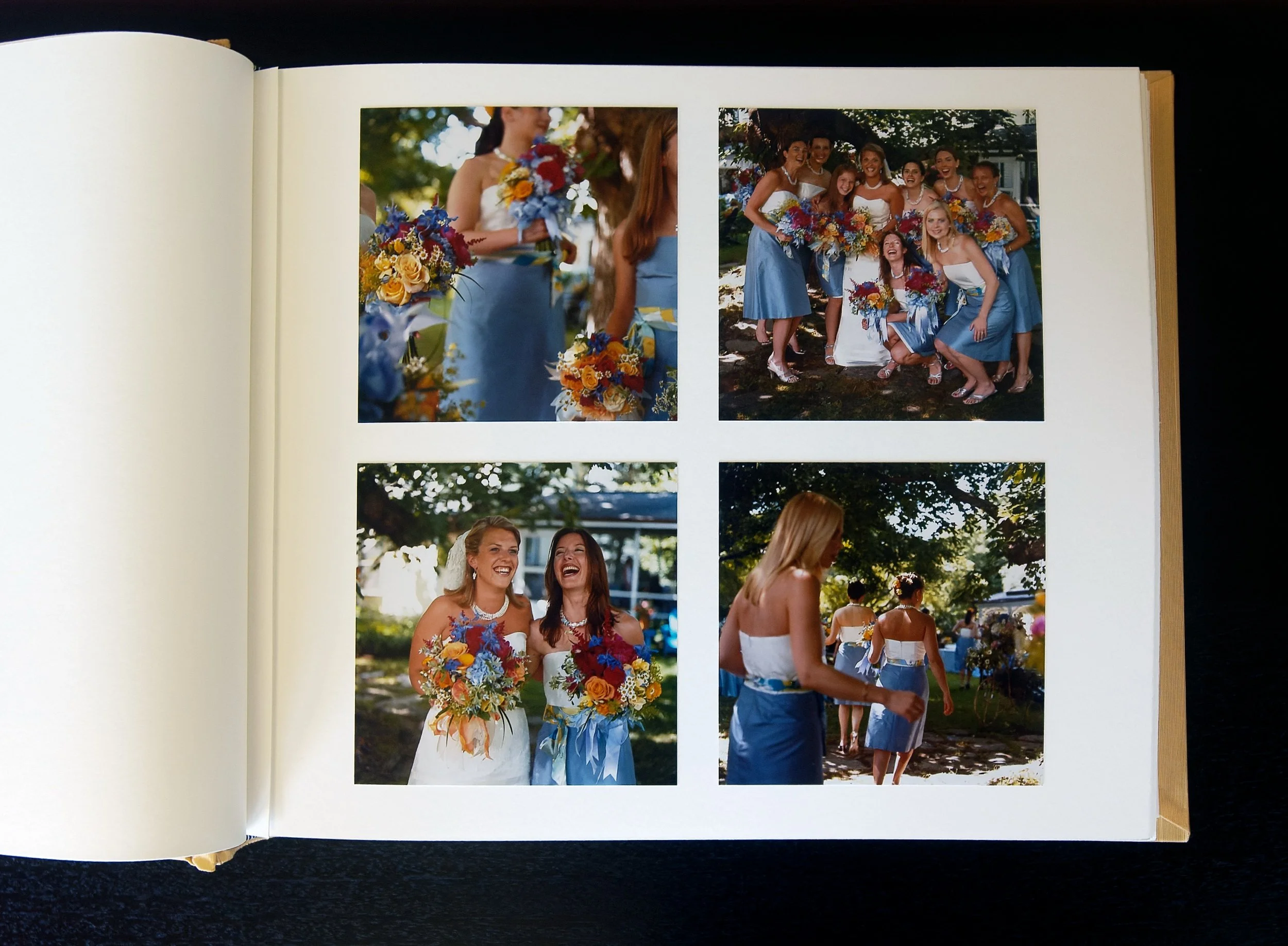 Open album with four square wedding photographs printed on pearl surface paper, hand-mounted.