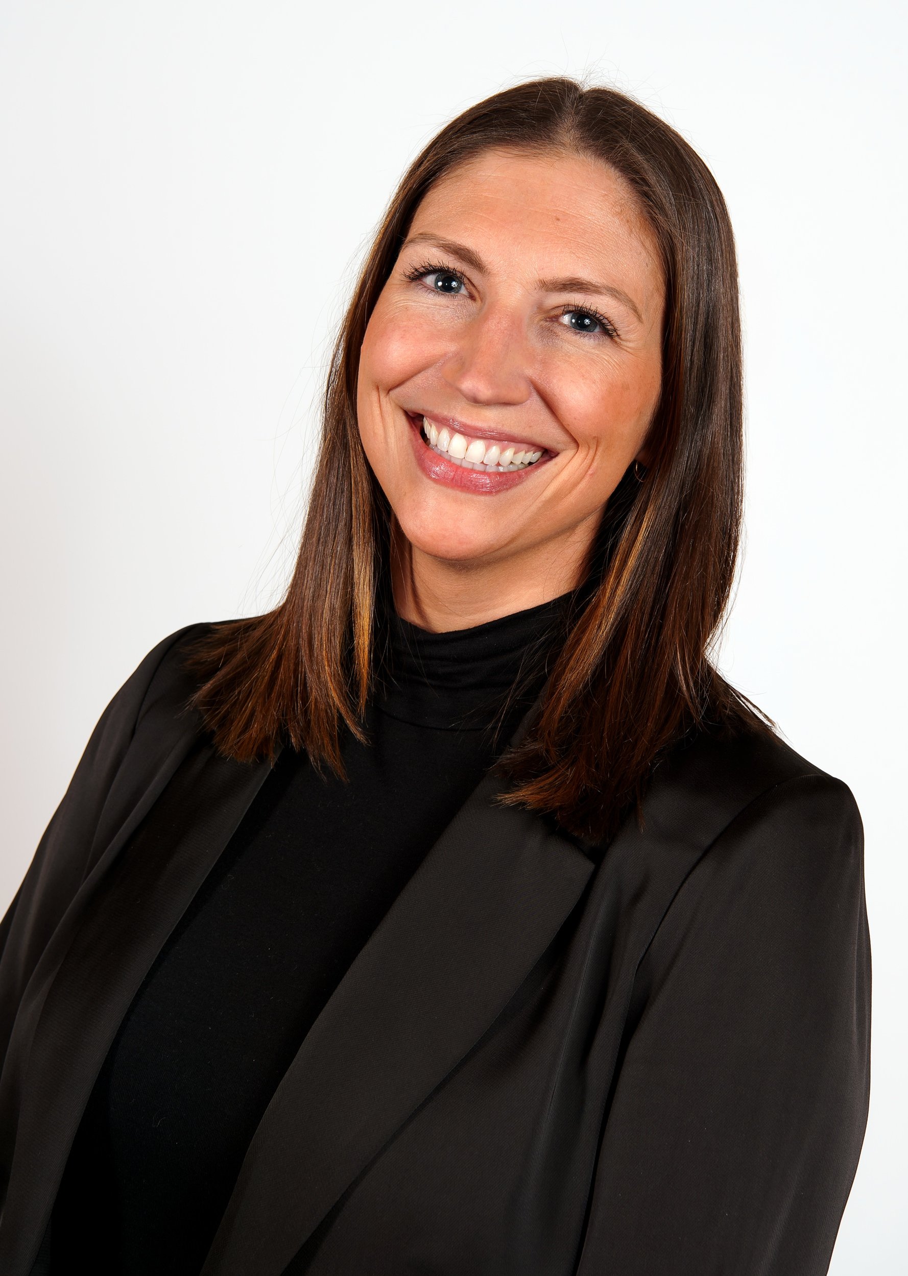 Workhuman executive portrait of a woman photographed against a white backdrop with controlled studio lighting.