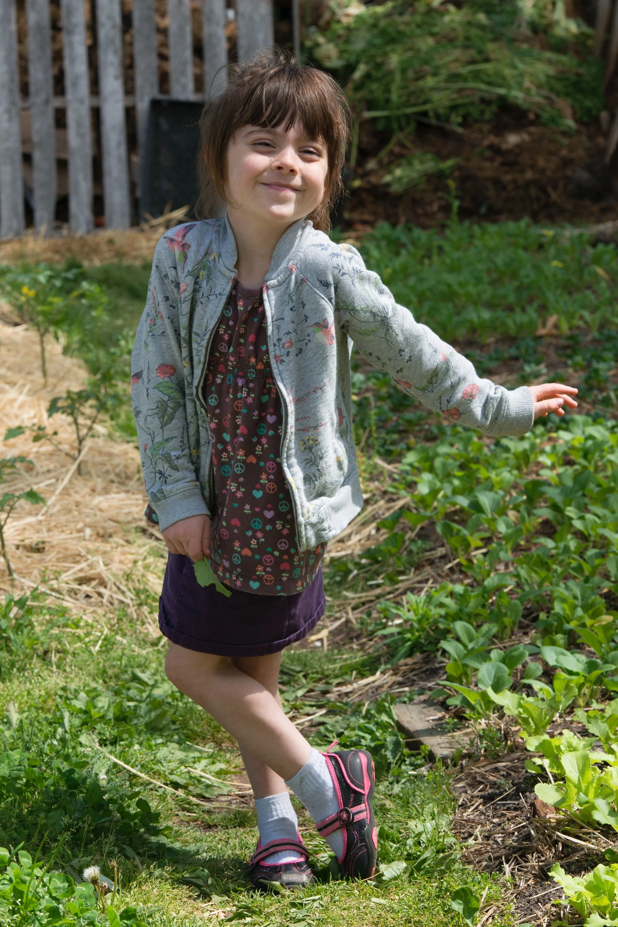 Young child strikes a pose at Southside Community Land Trust community gardens.