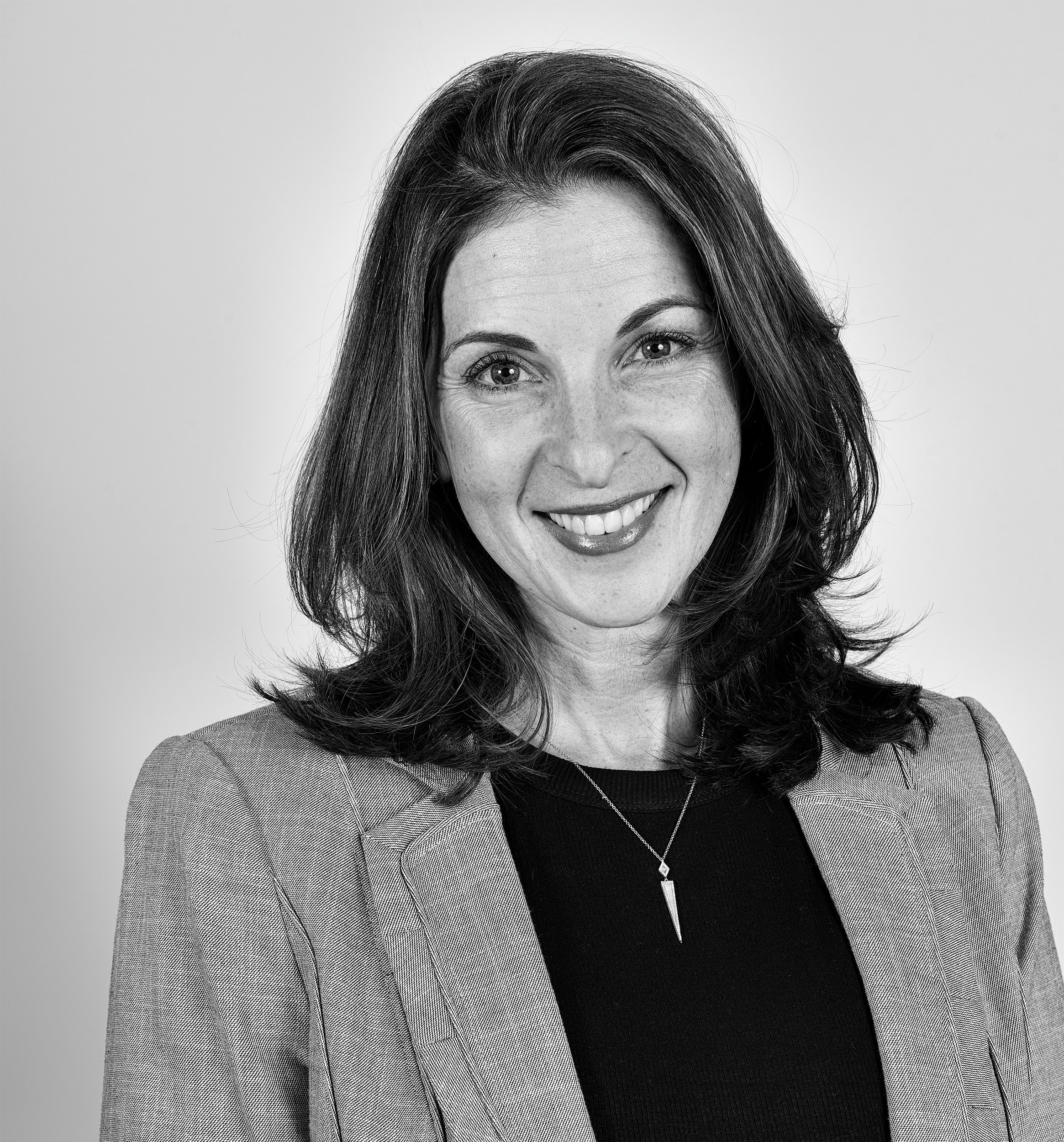 Authentic corporate portrait of a professional woman photographed against a neutral studio backdrop with studio lighting in Boston.