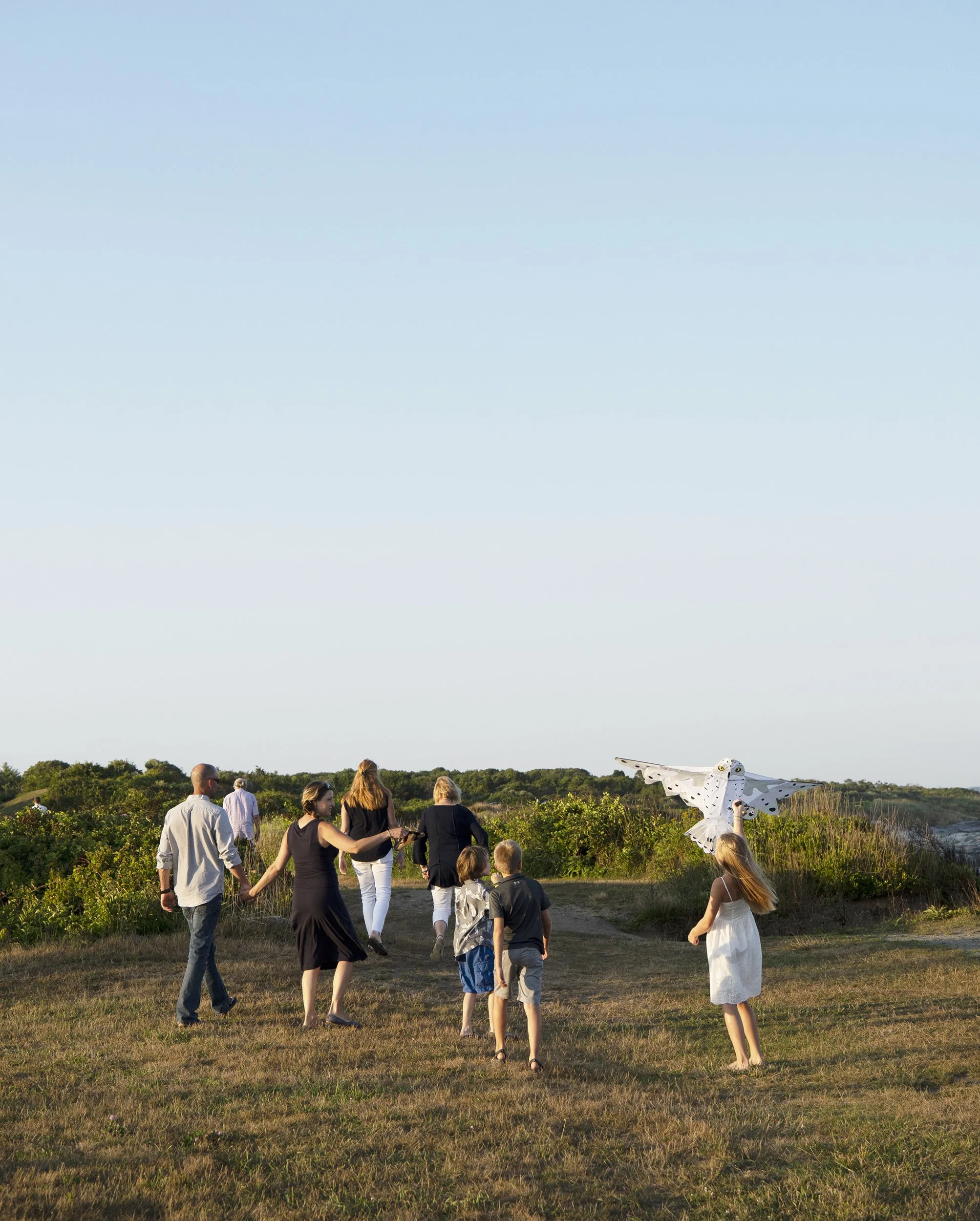 The entire family walking away from Beavertail Park in Jamestown, with backs toward the camera.